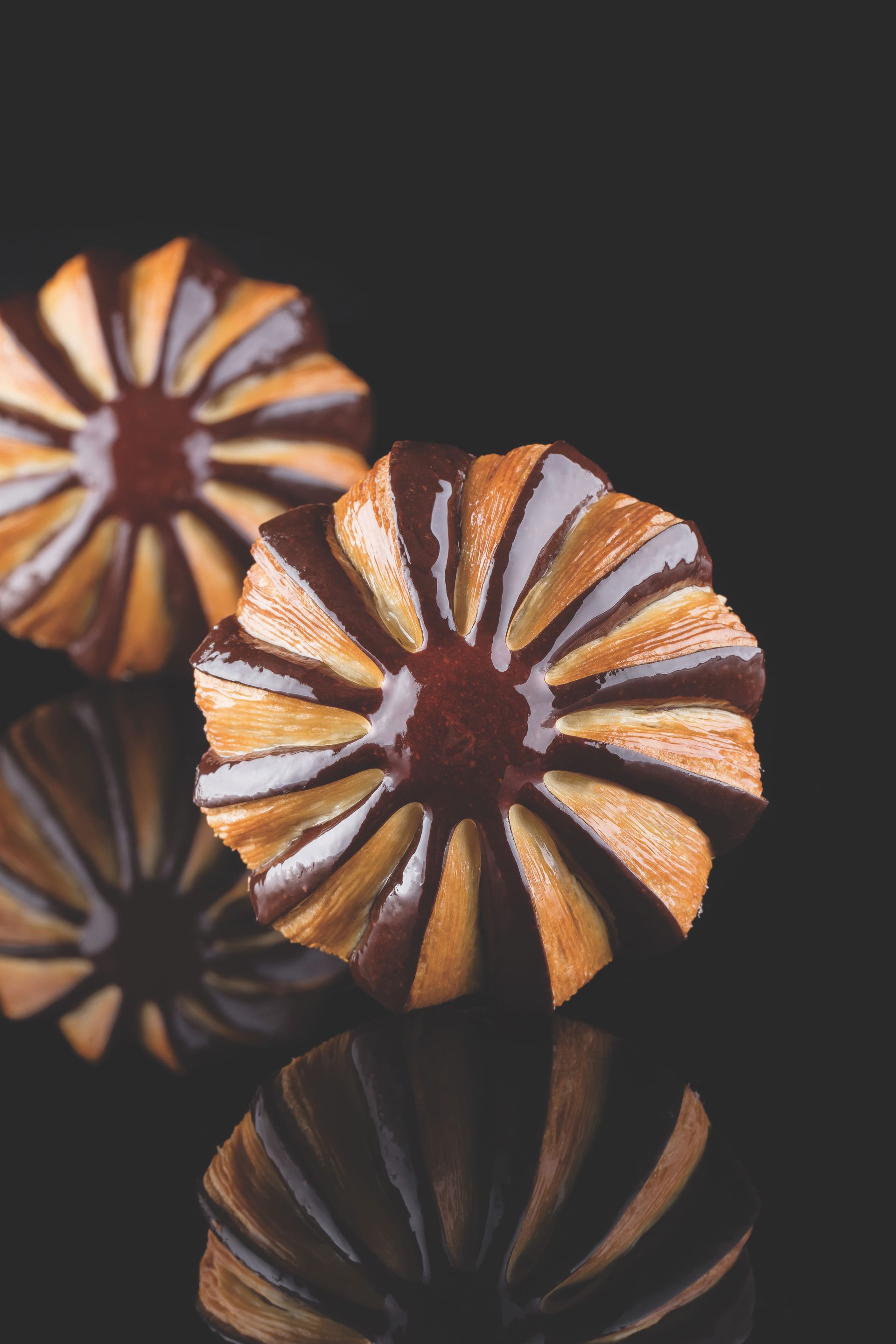 Un gros plan de trois biscuits au chocolat sur une surface noire