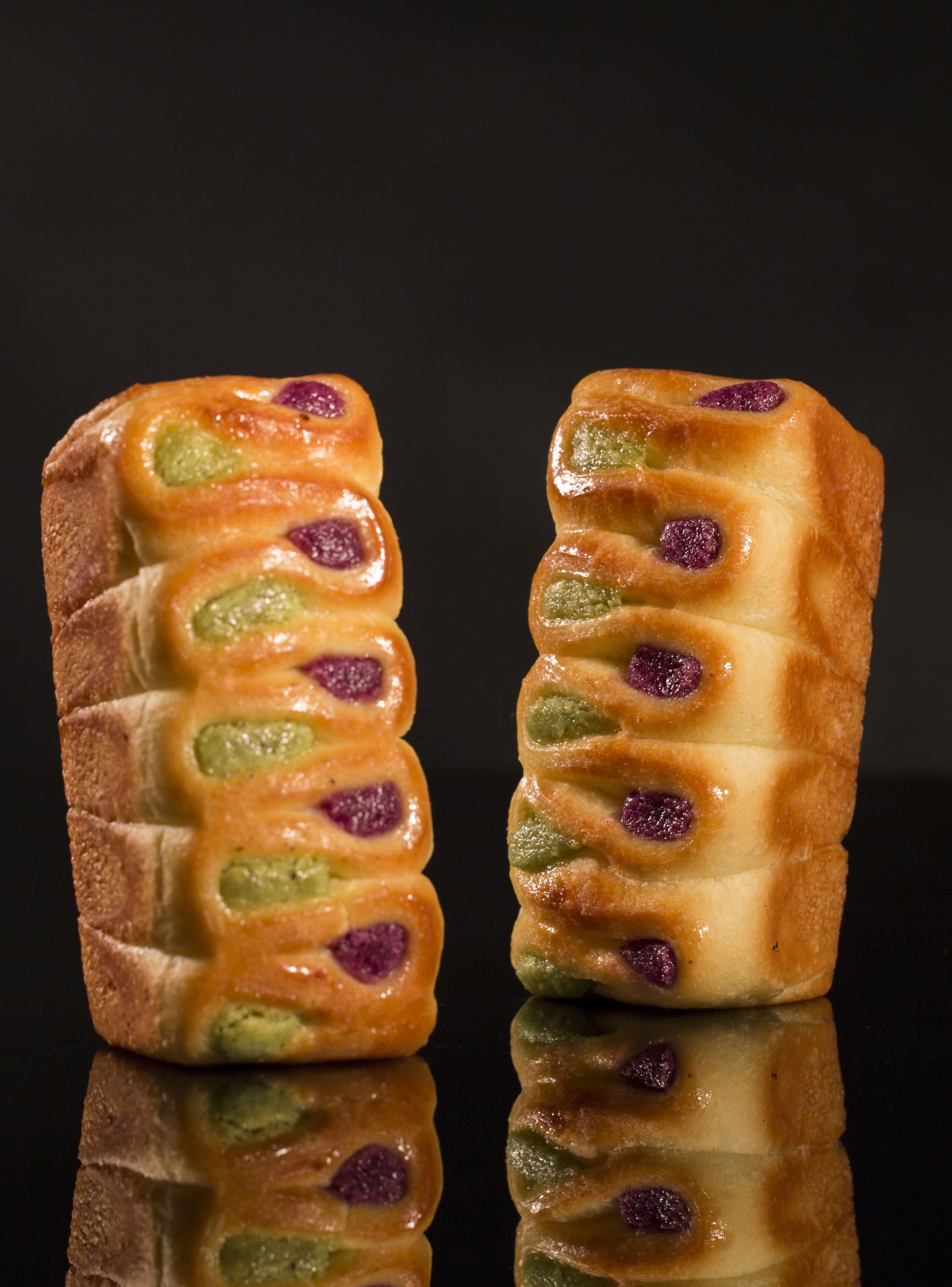 Deux pains sont posés l'un à côté de l'autre sur une surface noire.