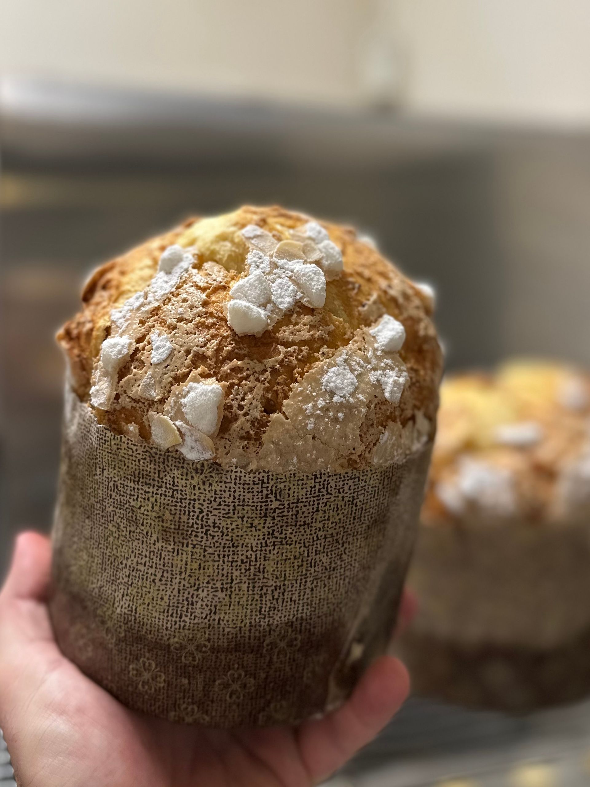 Une personne tient un muffin avec du sucre en poudre dessus