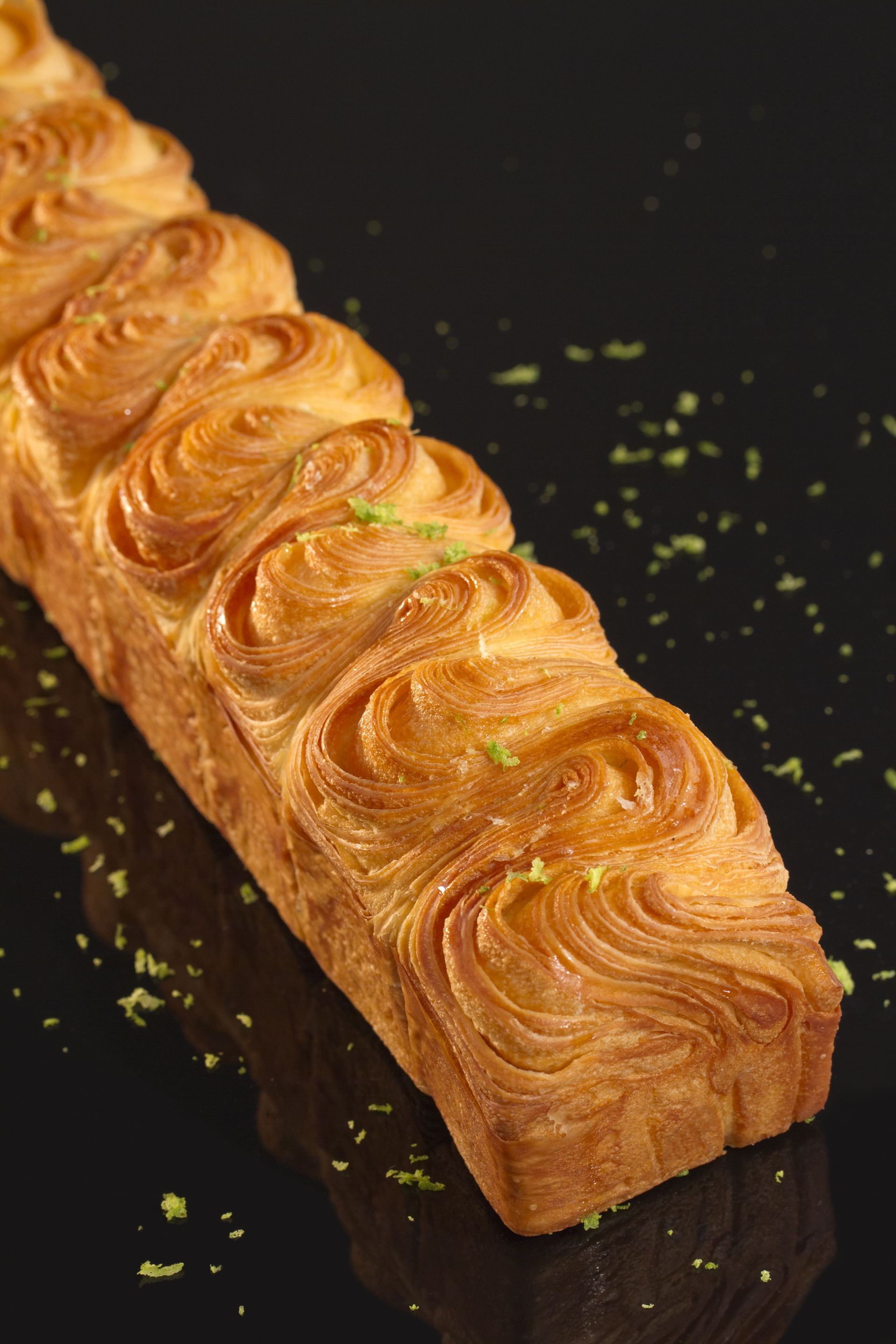 Une longue miche de pain est posée sur une surface noire.