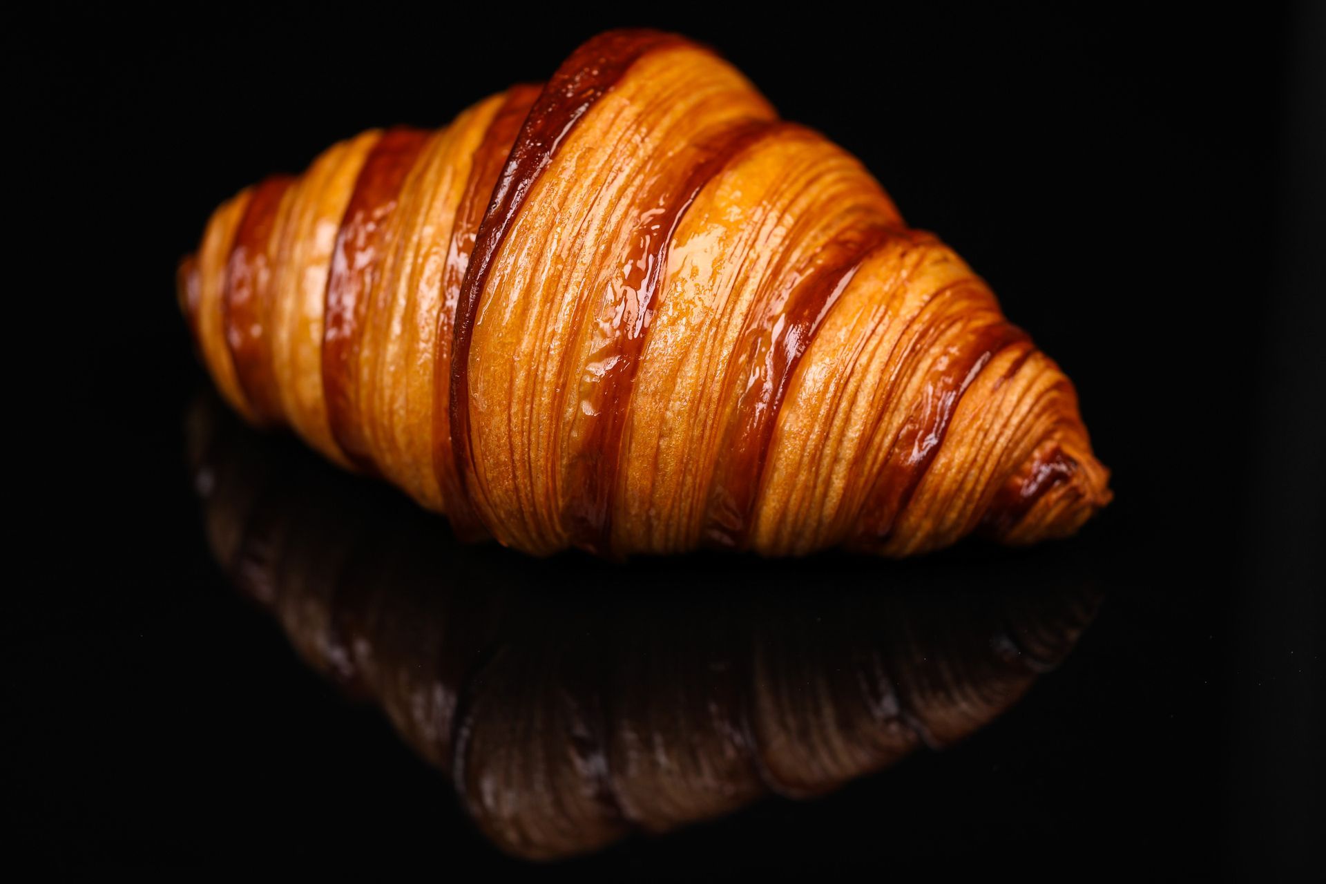 Un gros plan d'un croissant sur une surface noire.