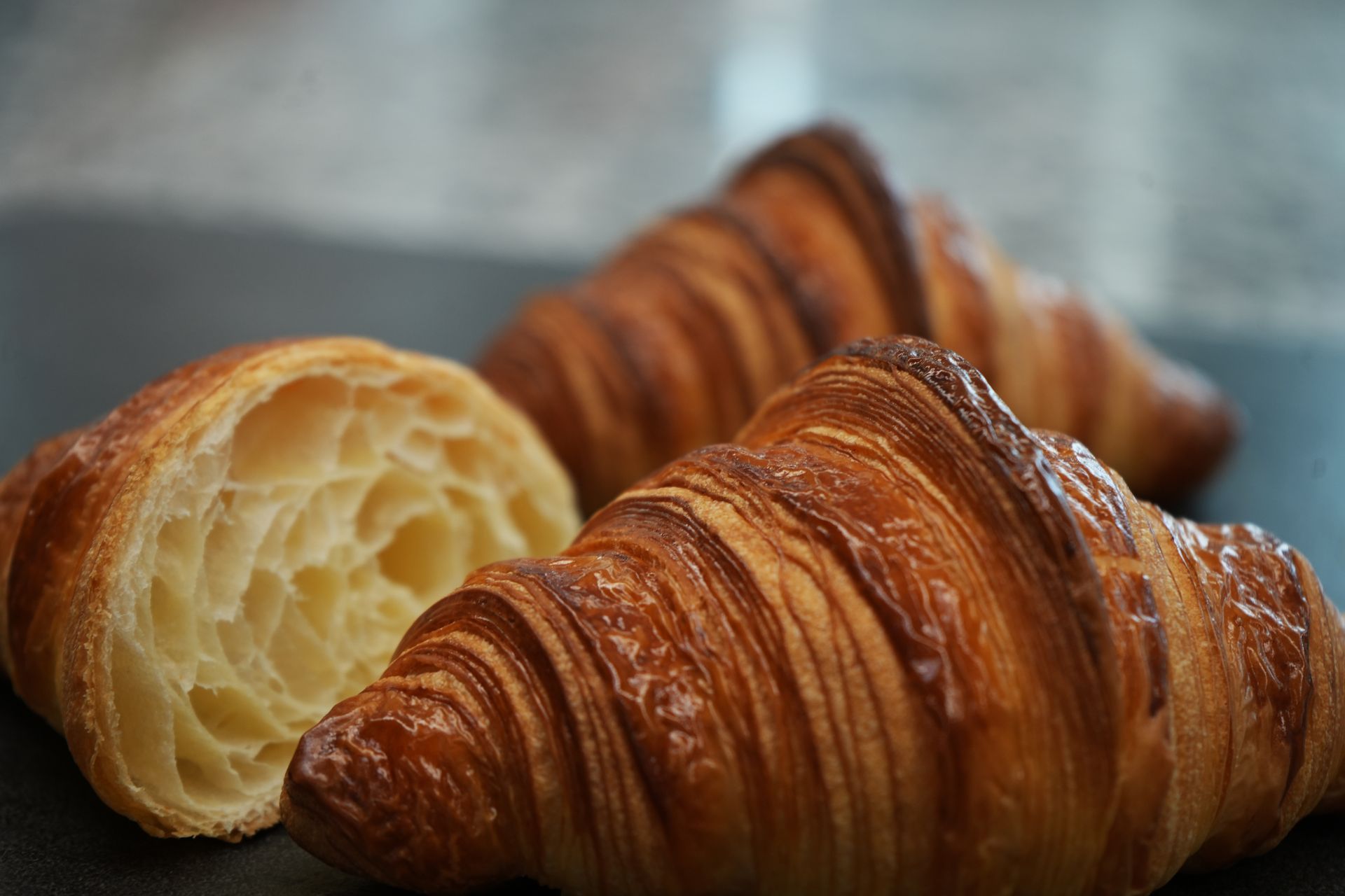 Un gros plan de deux croissants sur une table avec l'un coupé en deux.