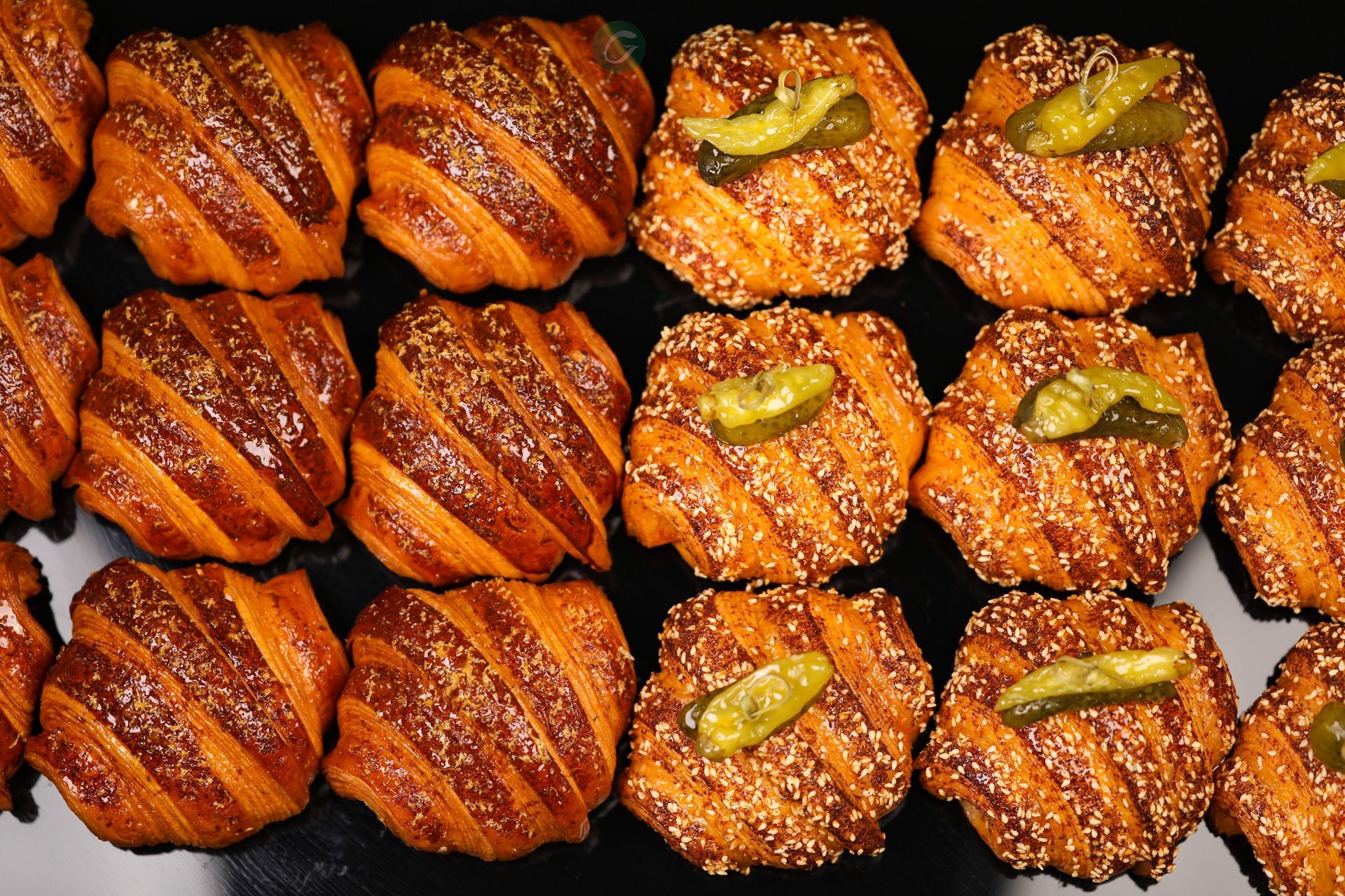 Un tas de pâtisseries avec des graines de sésame et des cornichons dessus