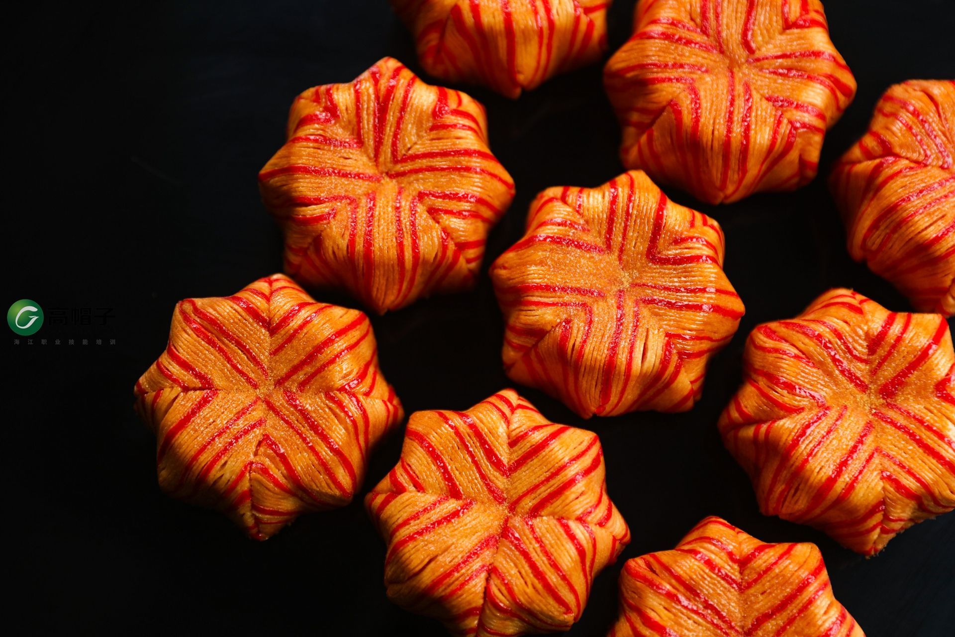 Un tas de biscuits rayés orange et rouges sur une surface noire.
