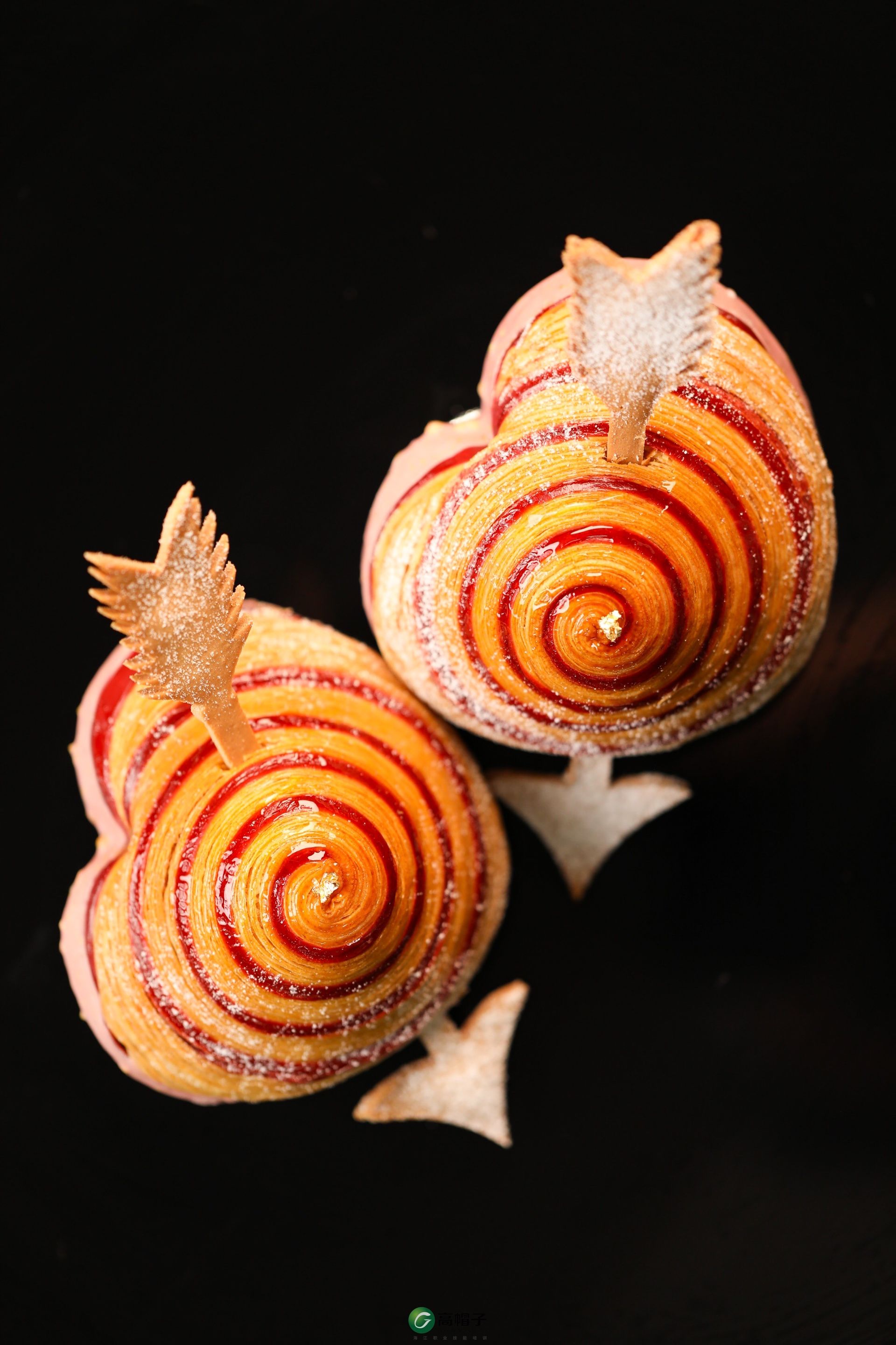 Deux cupcakes en forme d'escargot sur fond noir.