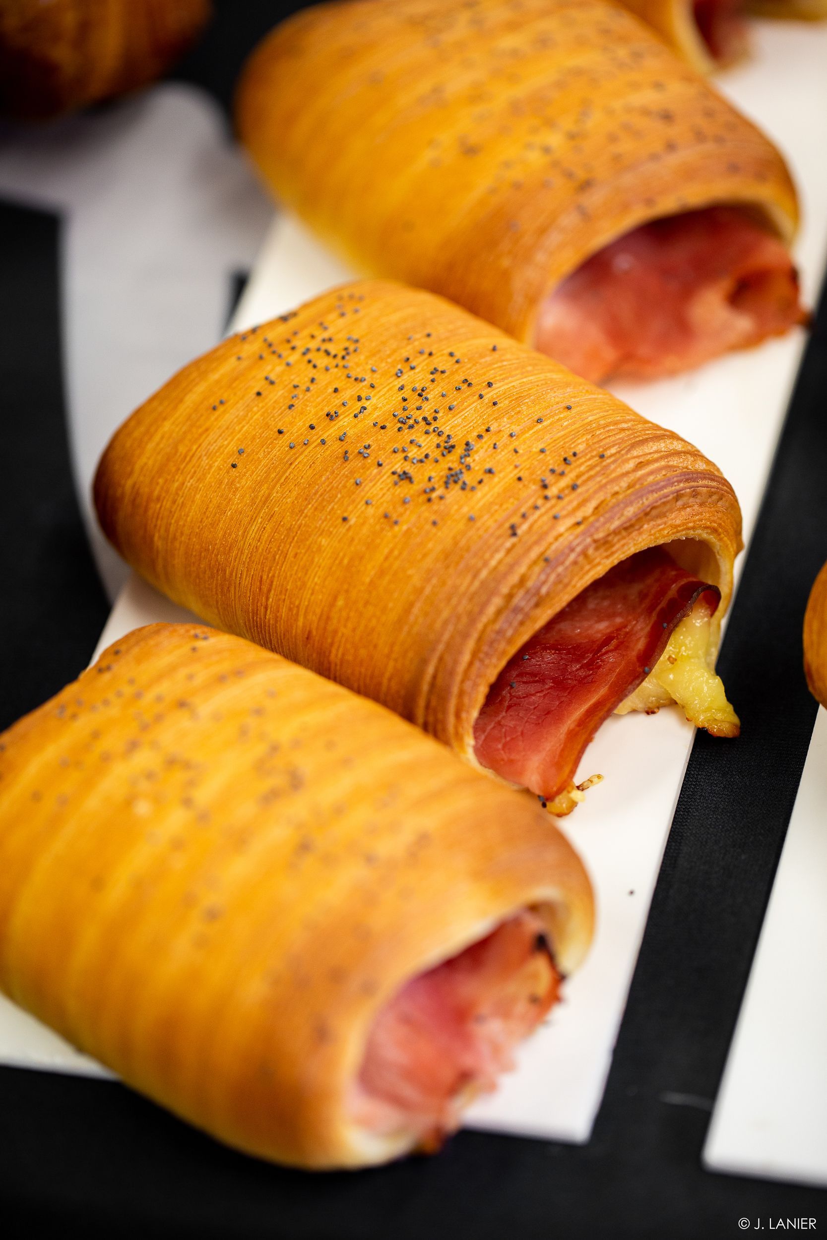 Un gros plan de trois rouleaux de nourriture sur une table.