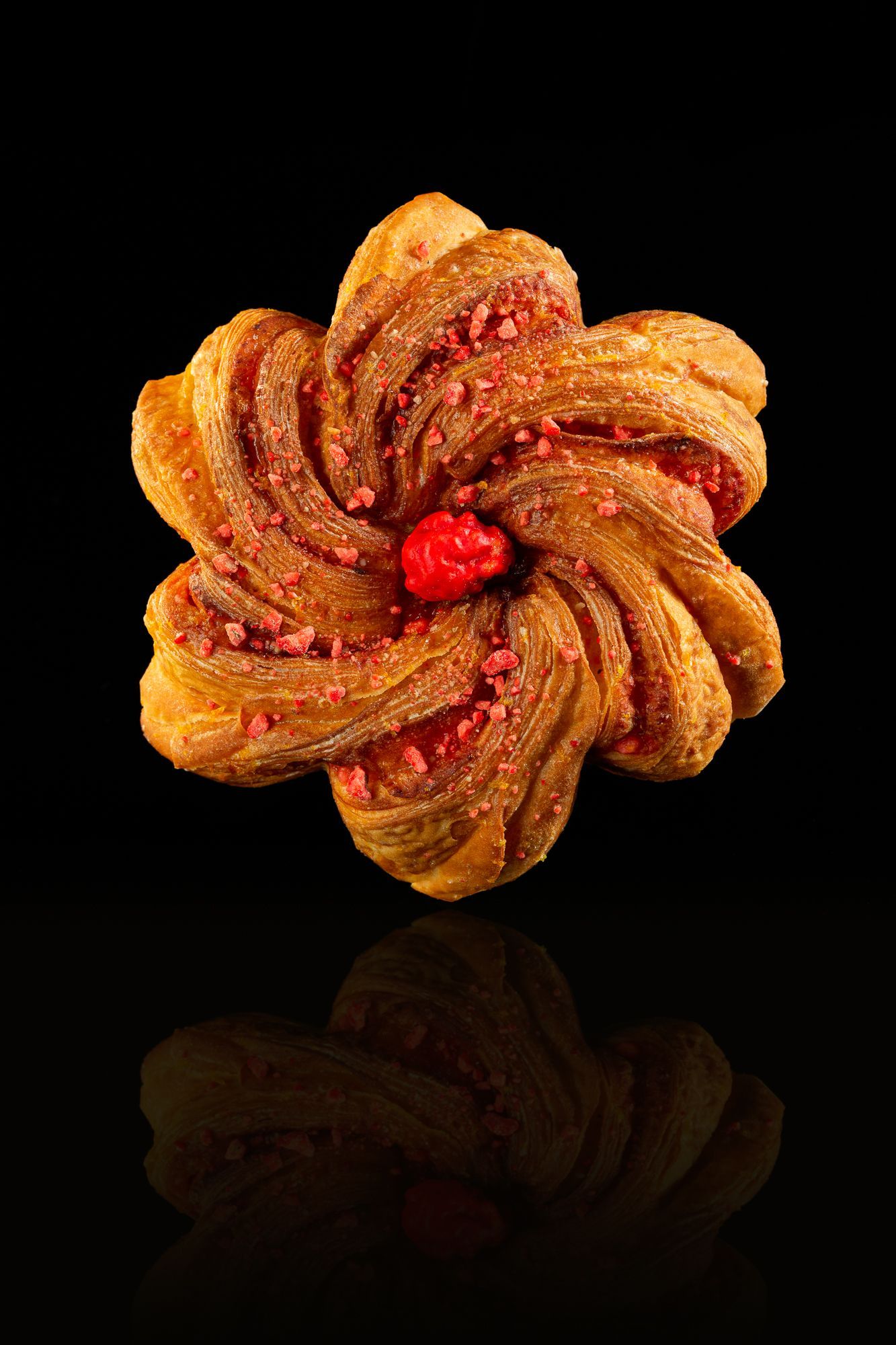 Un gros plan d'une pâtisserie en forme de fleur sur fond noir.