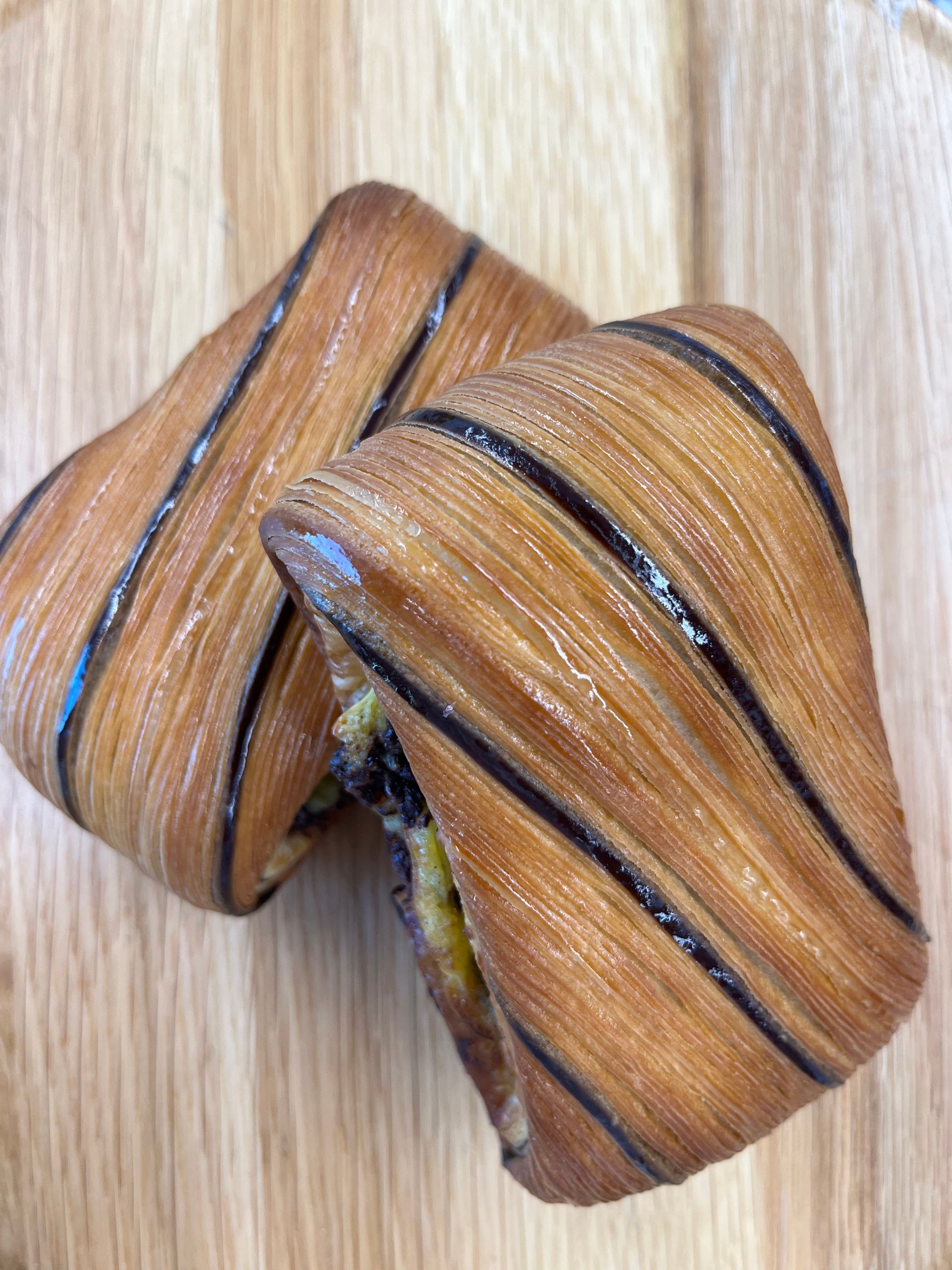 Un gros plan de deux croissants sur une table en bois.