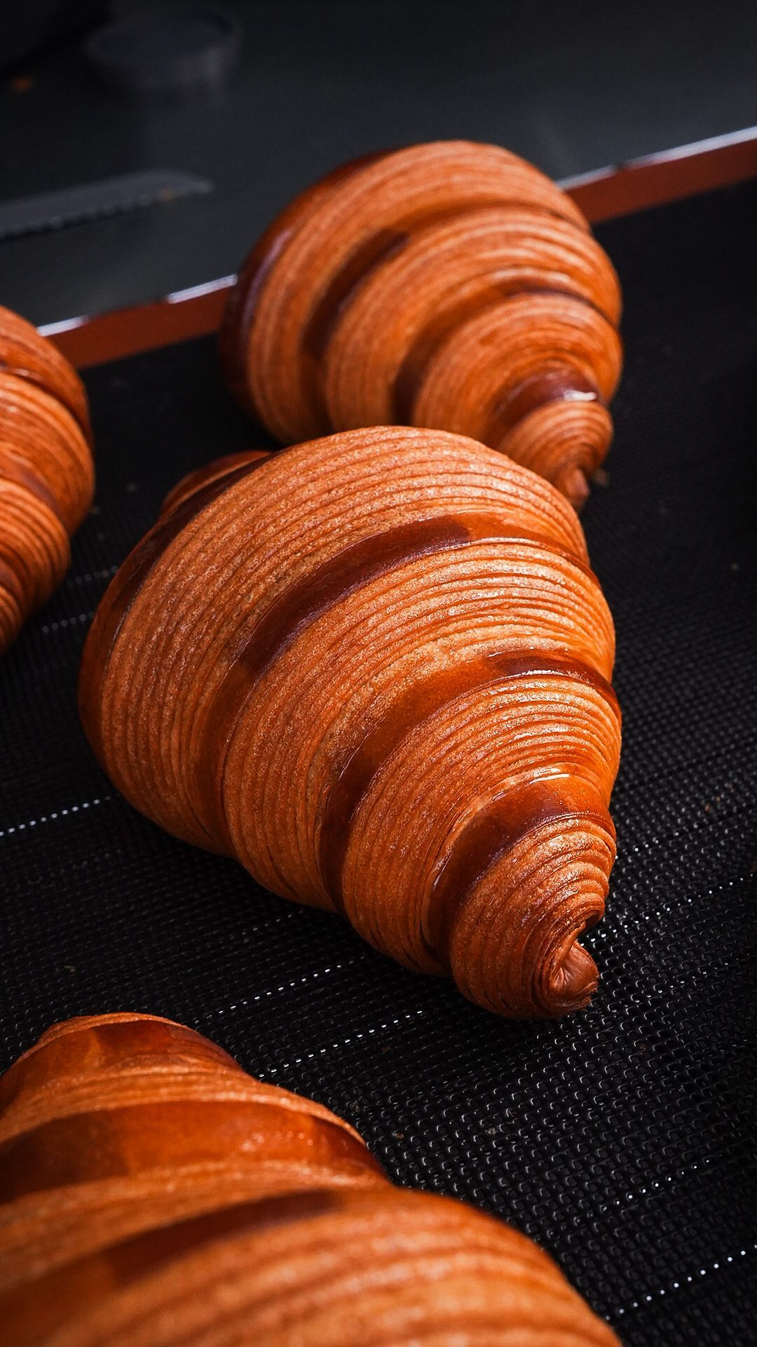 Un tas de croissants est posé sur un tapis noir.