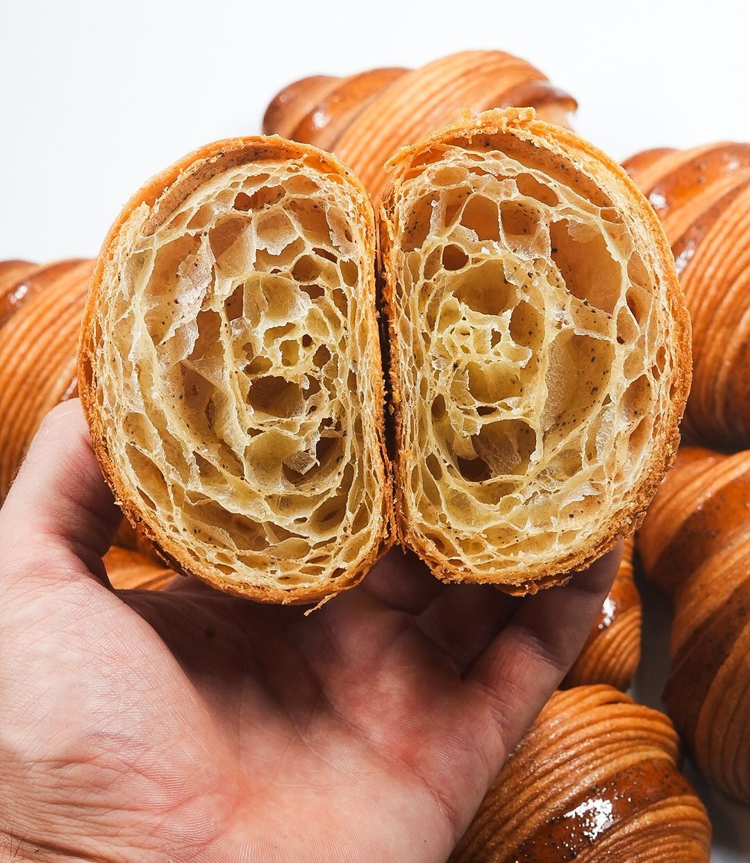 Une personne tient un croissant coupé en deux