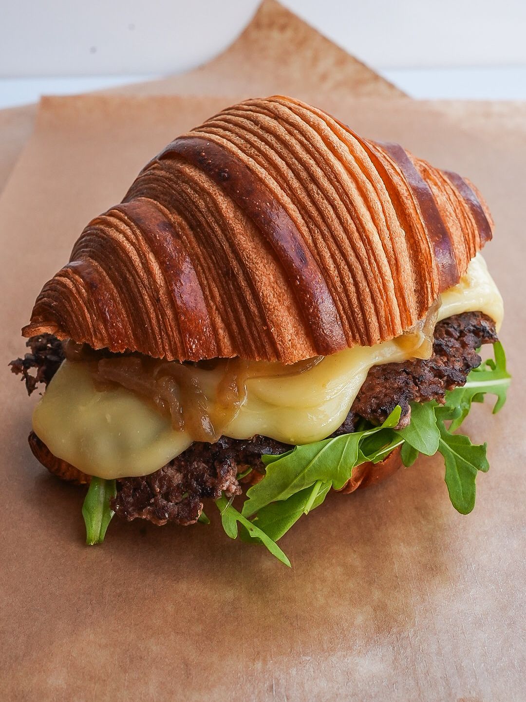 Un gros plan d'un sandwich sur un croissant sur une table.