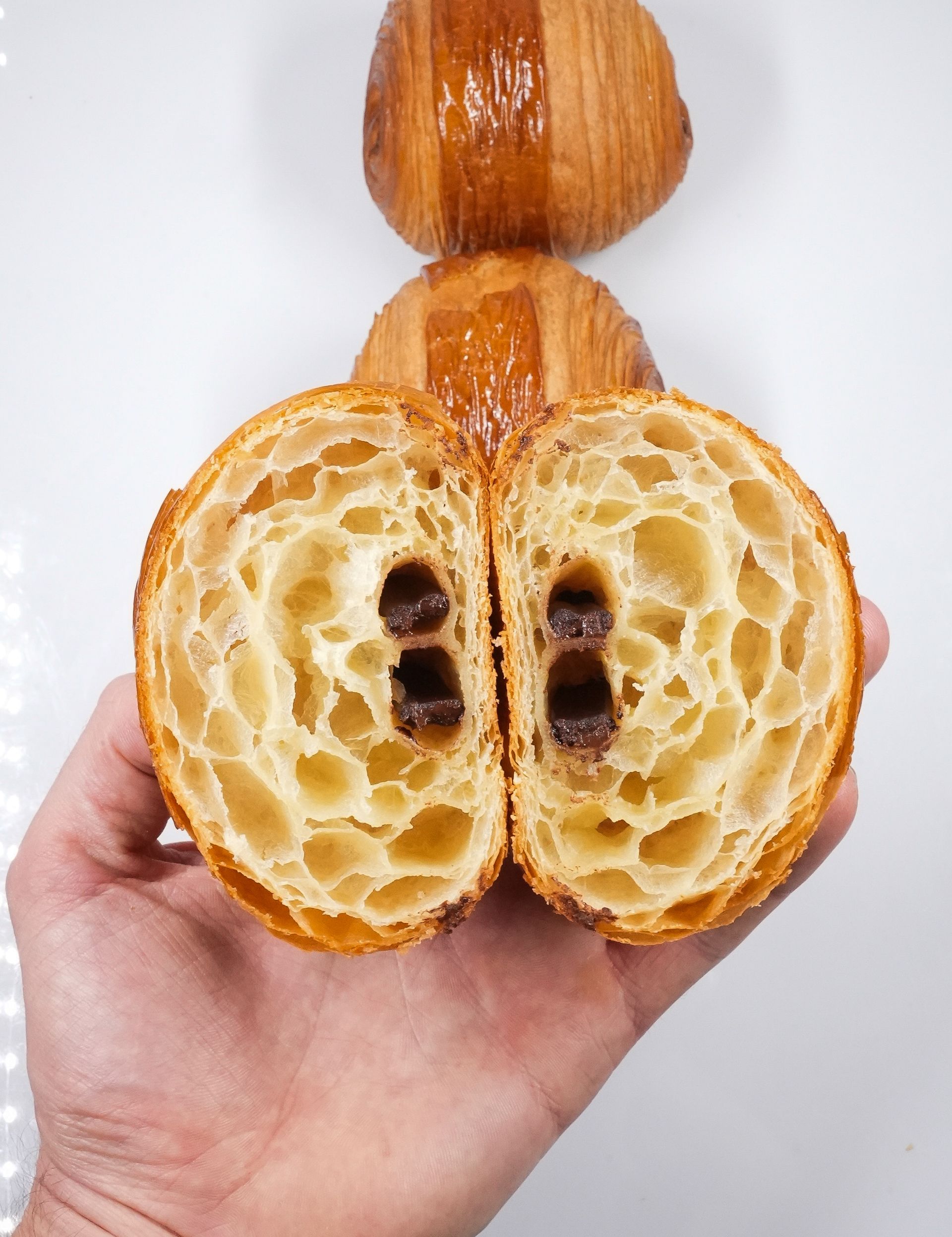 Une personne tient un croissant coupé en deux