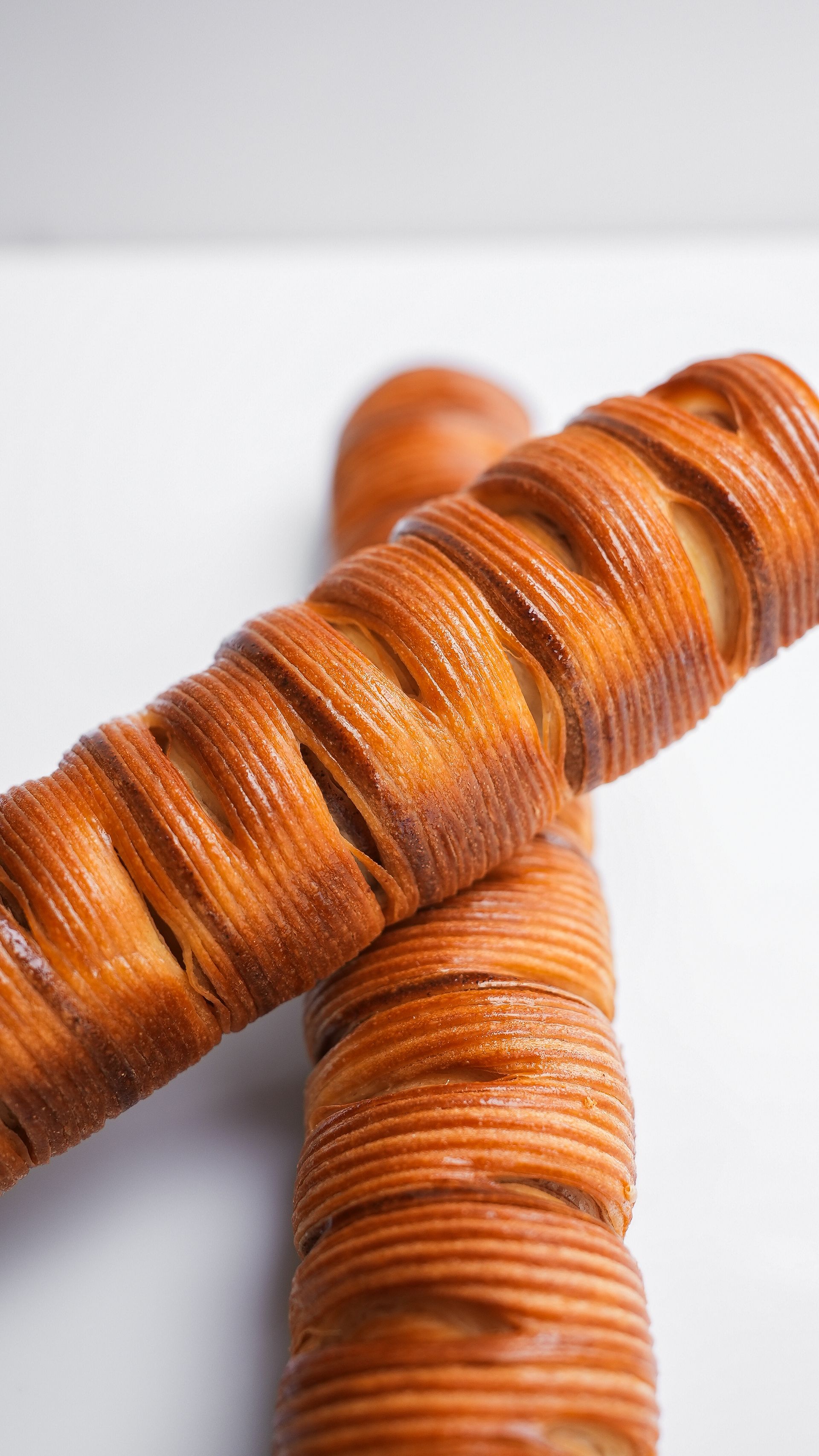 Deux petits pains sont empilés l'un sur l'autre sur une surface blanche.