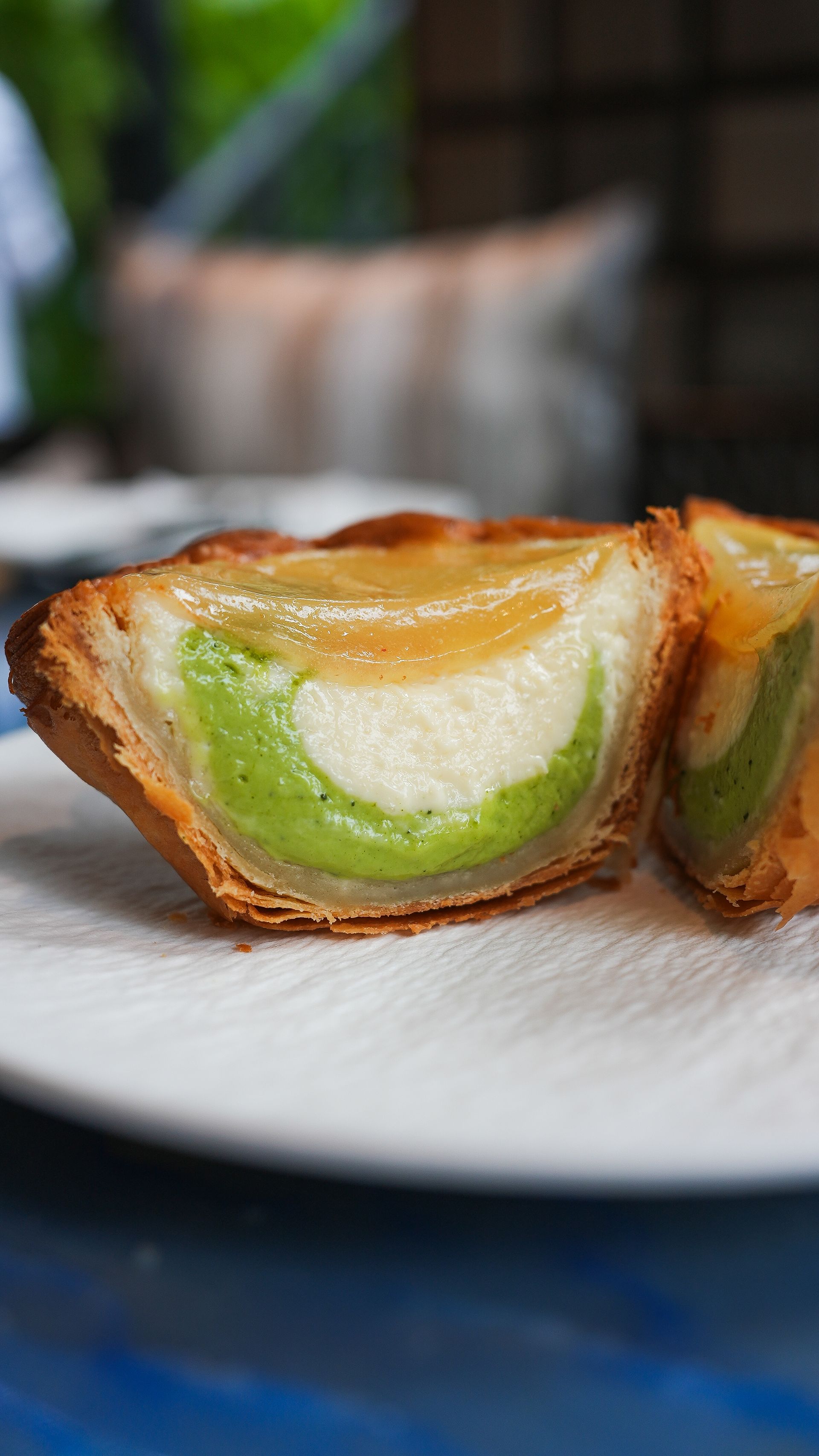 Un gros plan d'une pâtisserie avec une garniture verte sur une assiette.