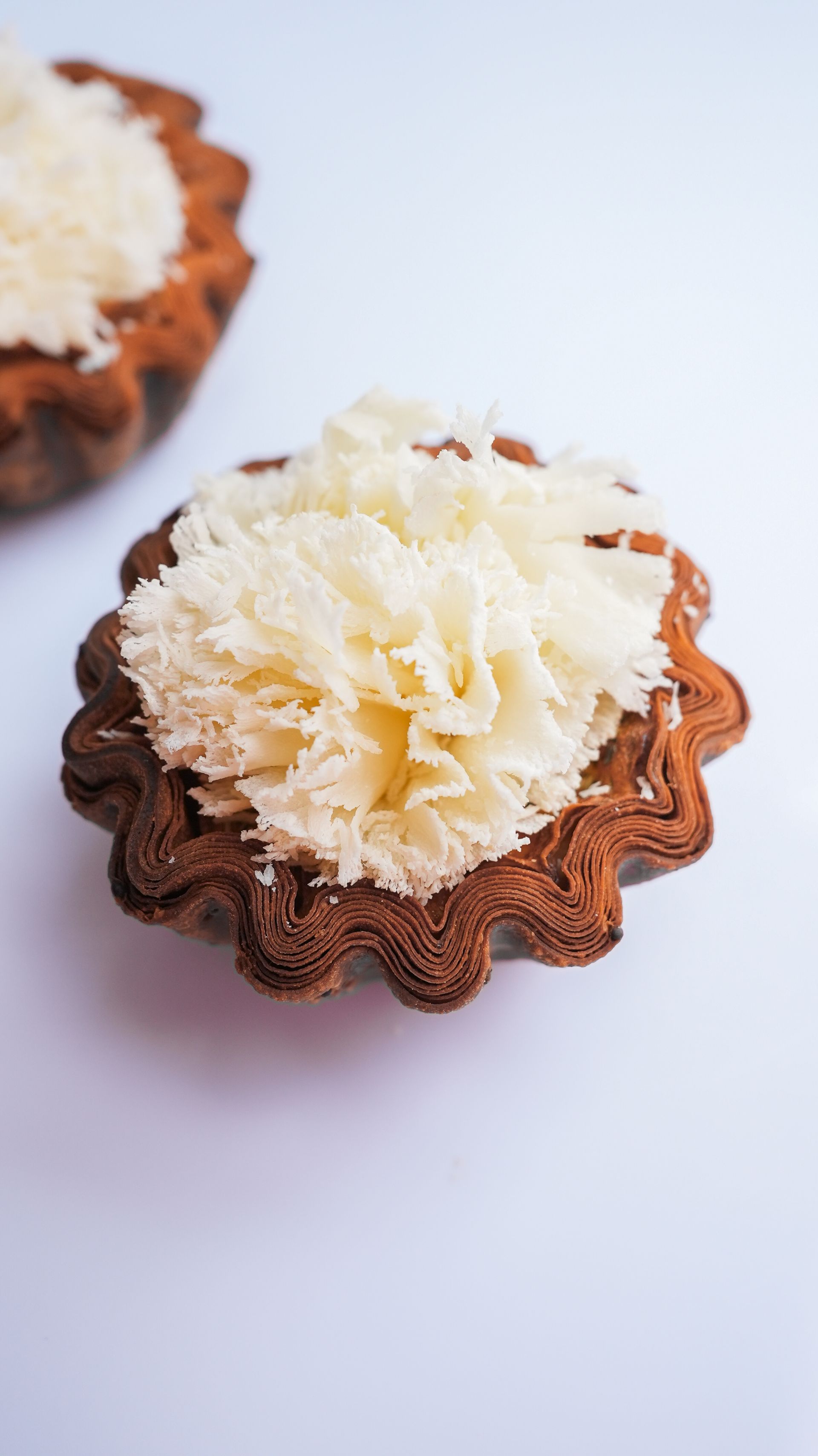 Un gros plan d'un cupcake avec du glaçage blanc sur une surface blanche.