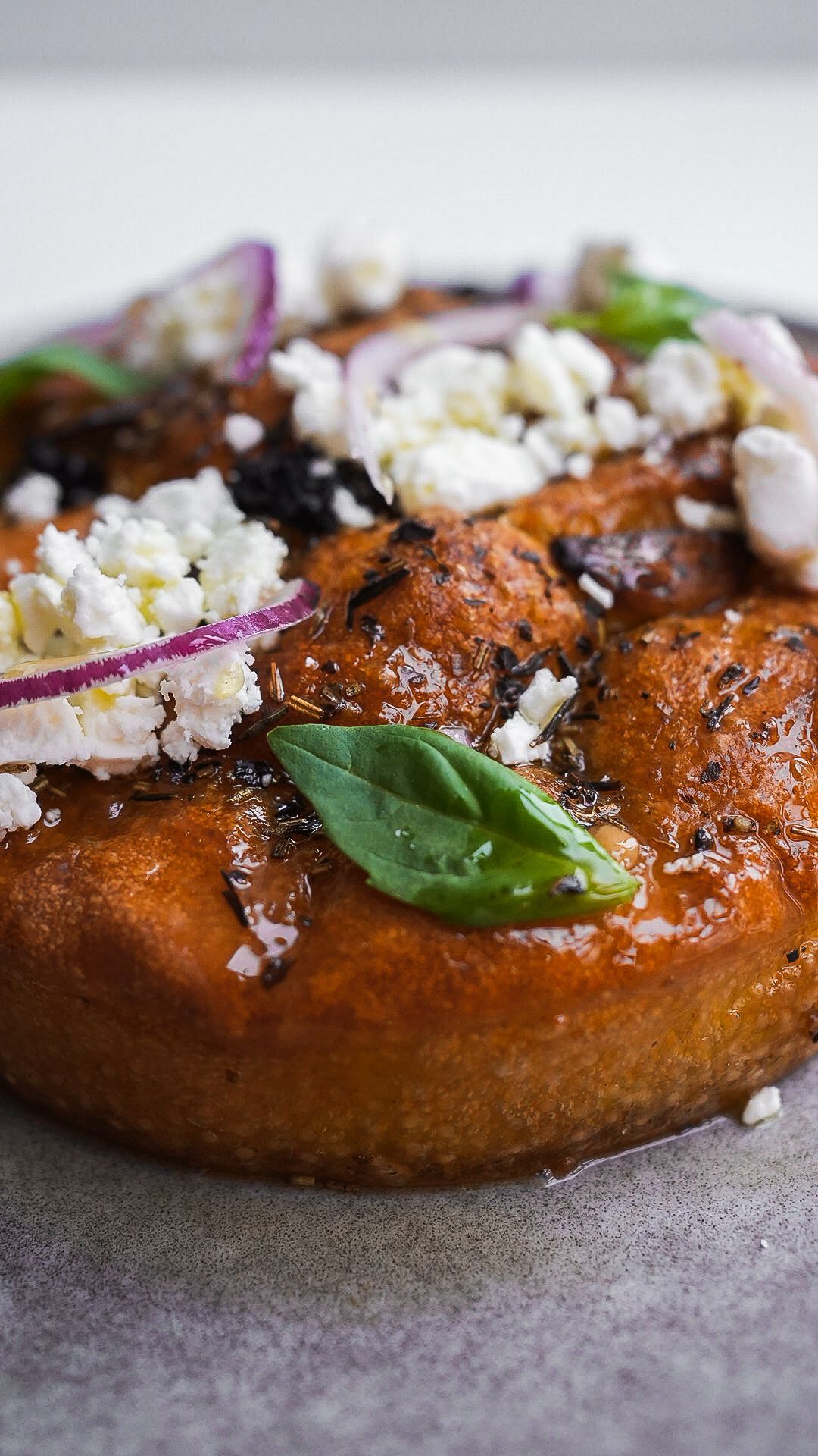 Un gros plan d'une pizza avec du fromage et des oignons sur une assiette.