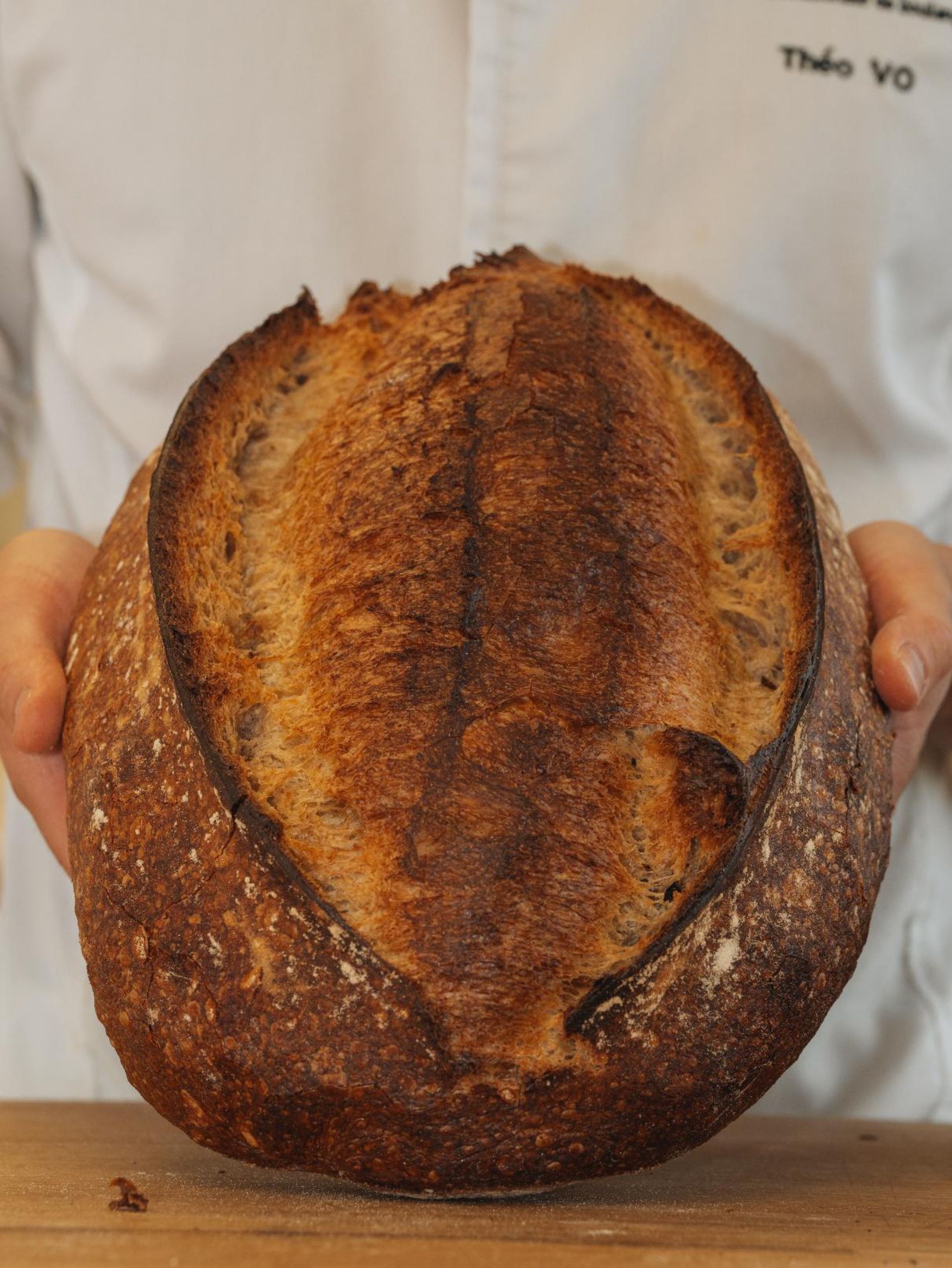 Une personne tient une miche de pain dans ses mains