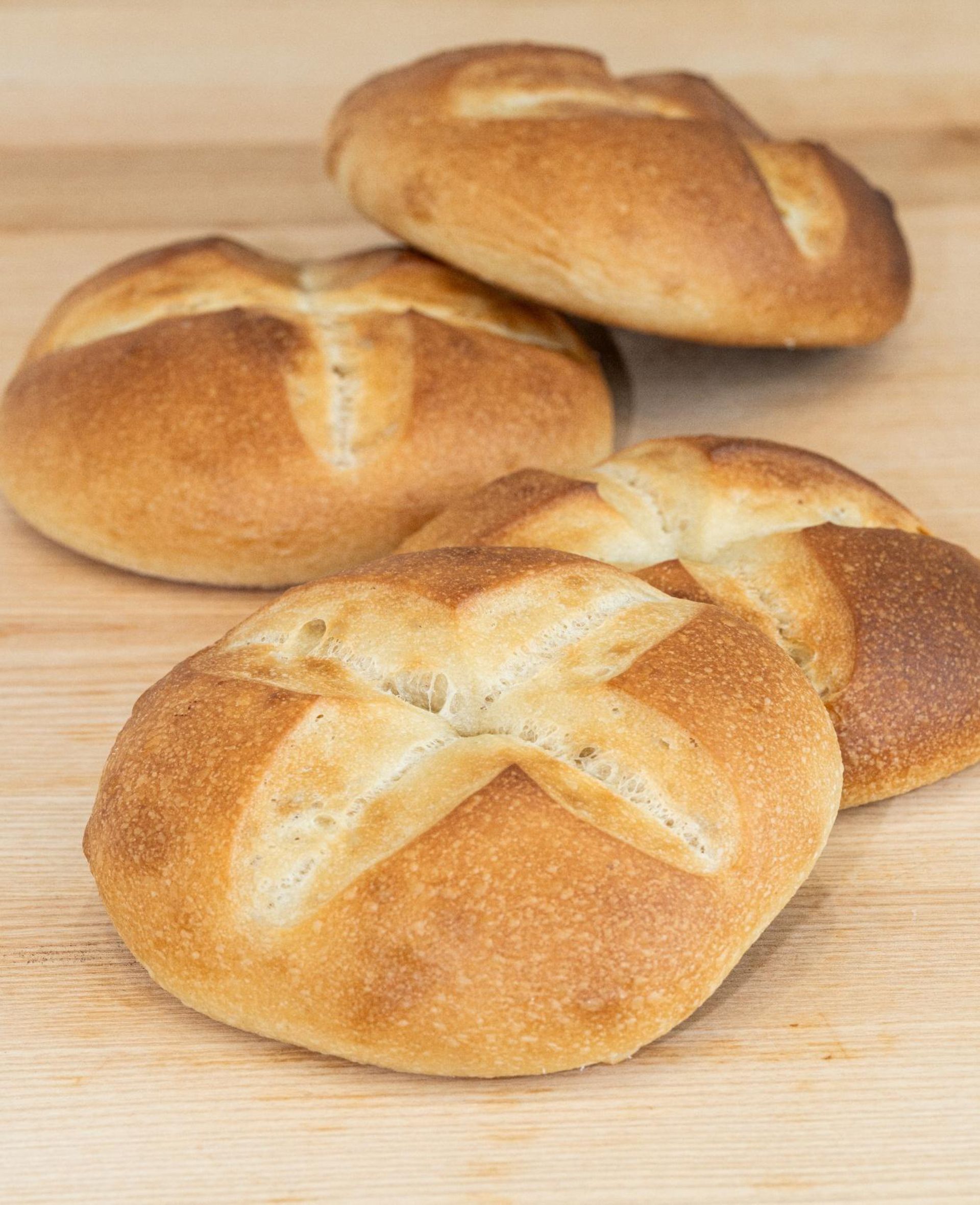 Quatre rouleaux sont posés les uns sur les autres sur une table en bois.