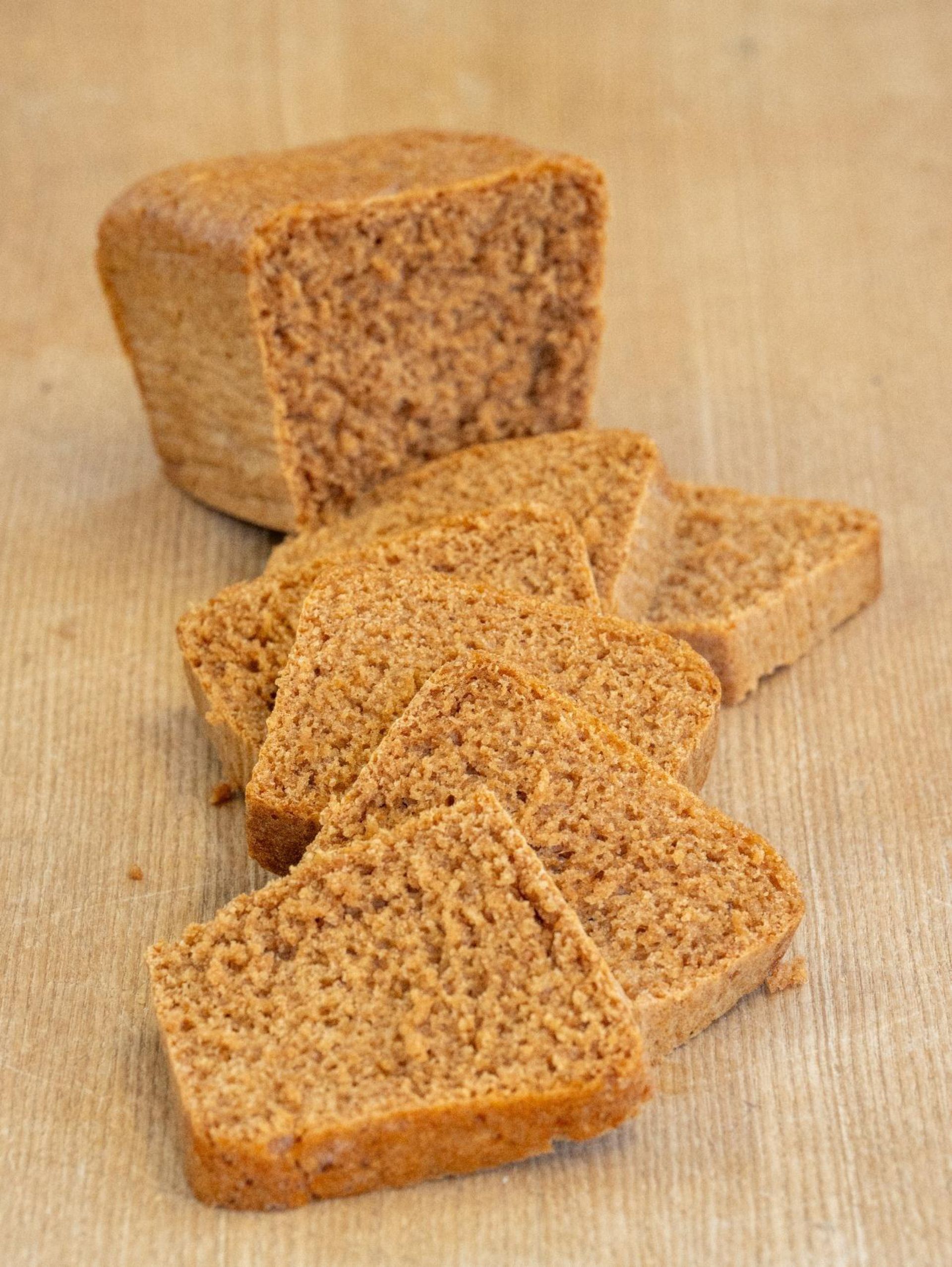 Une miche de pain est posée sur une table à côté de tranches de pain.