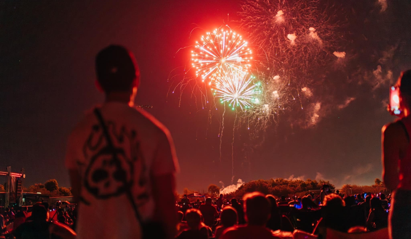 A large group of citizens watching fireworks at Marana park in Tucson.