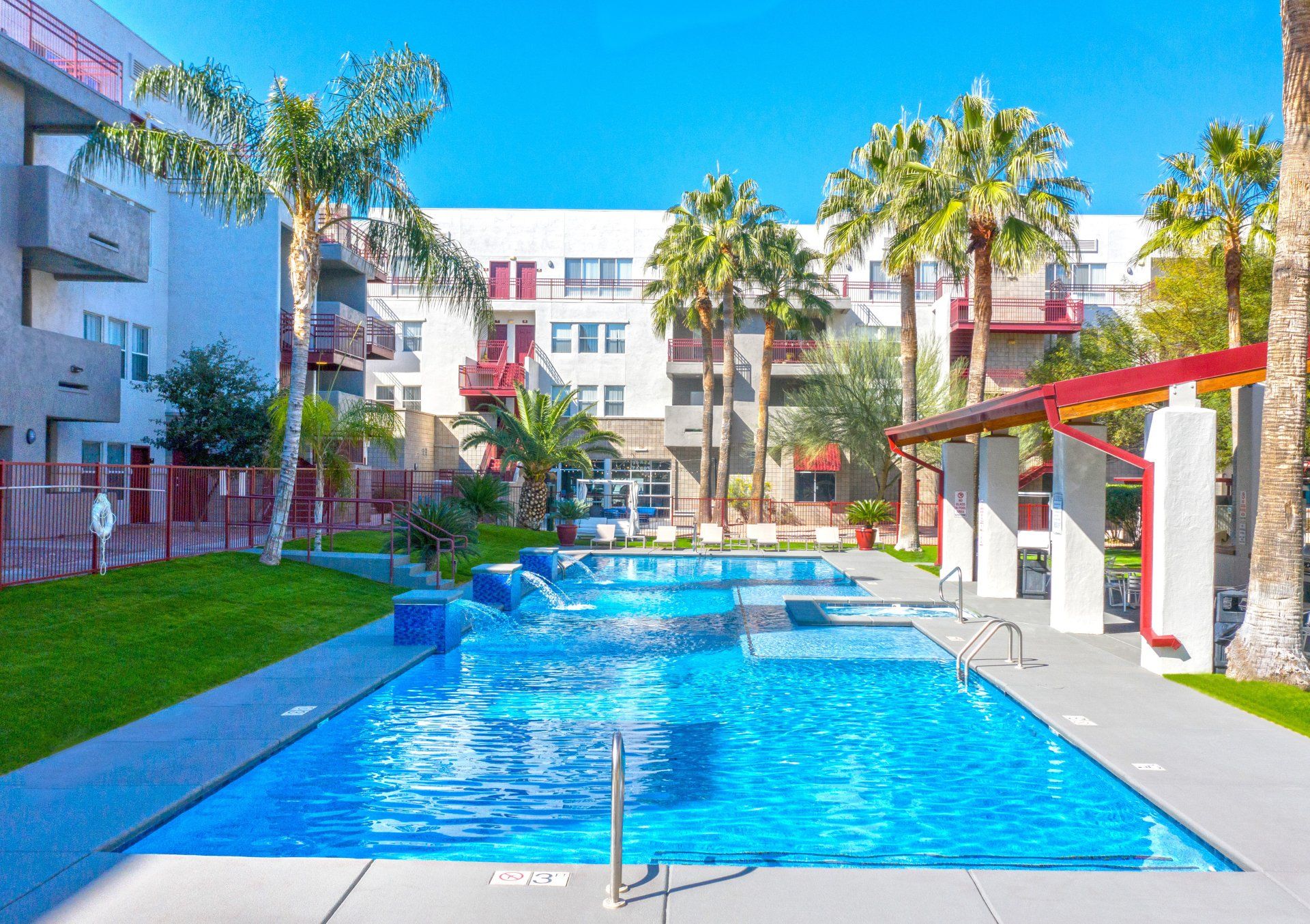 An image of the pool and hot tub with lounge chairs at the center of the complex. 