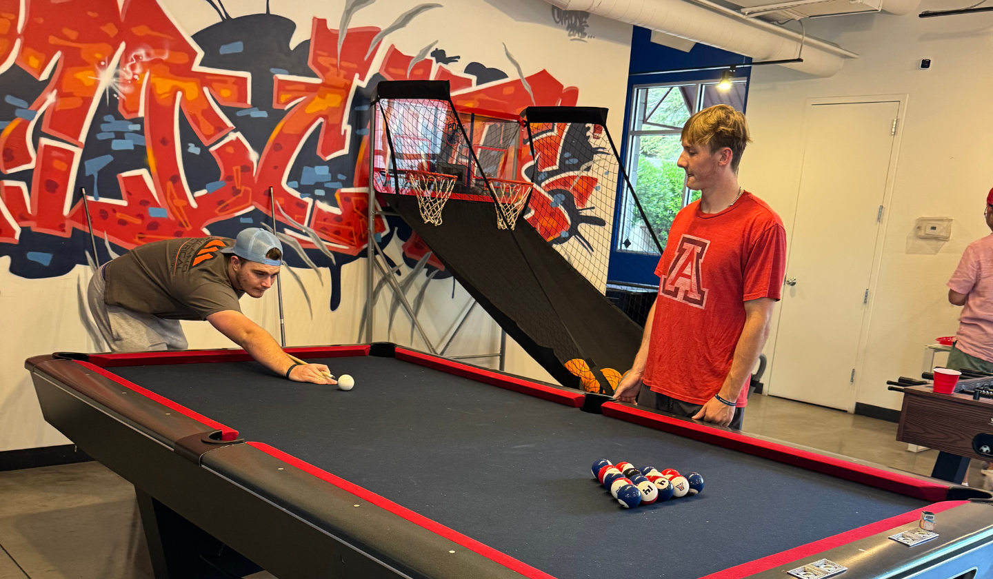 Two male residents playing pool at the Clubhouse.