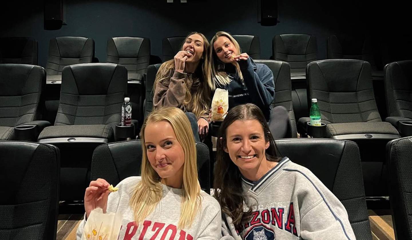 Four female residents hosting movie nights with friends in the spacious theater room at The Seasons Tucson.