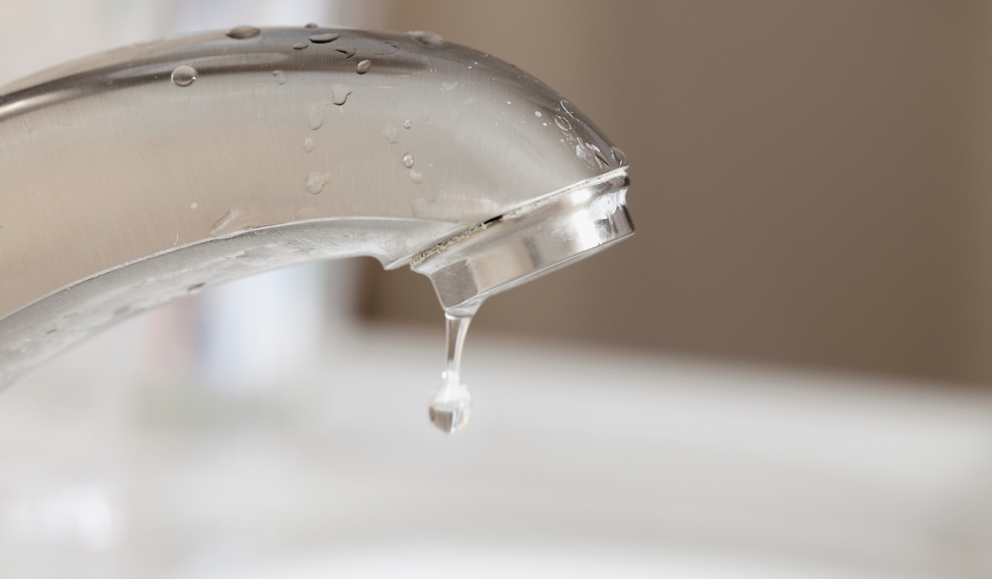 Leaky faucet with water dripping.