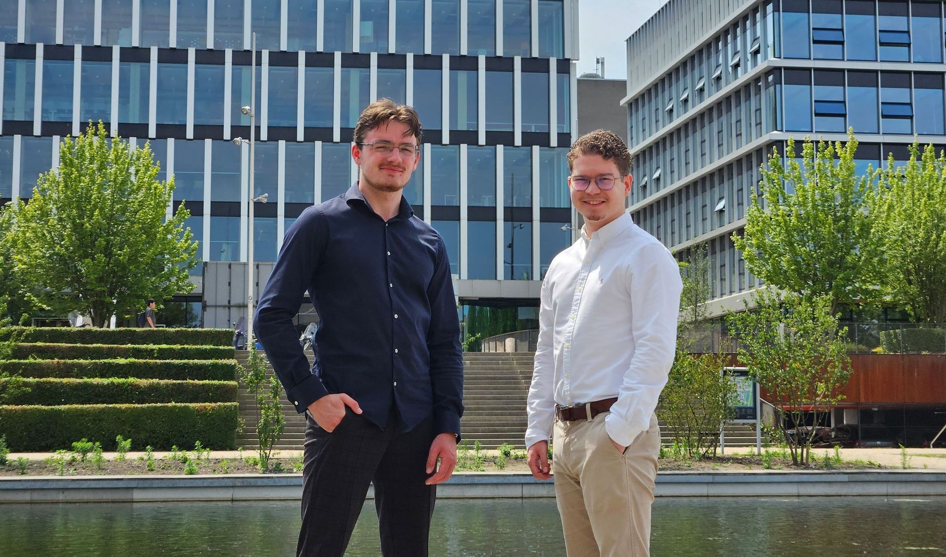 Twee mannen poseren voor een foto en een van hen steekt zijn duim omhoog.