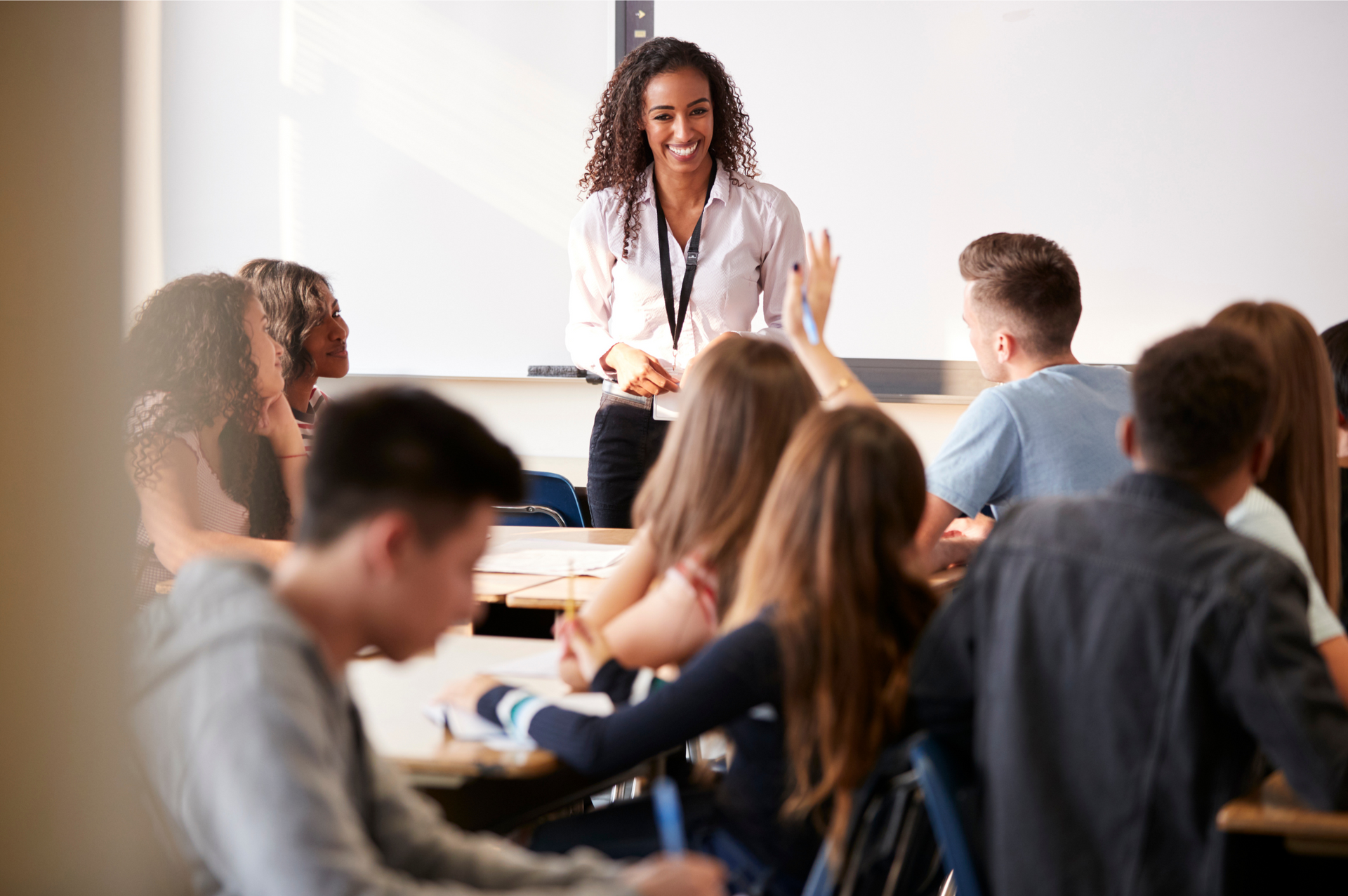 A teacher is giving a presentation to a group of students in a classroom.