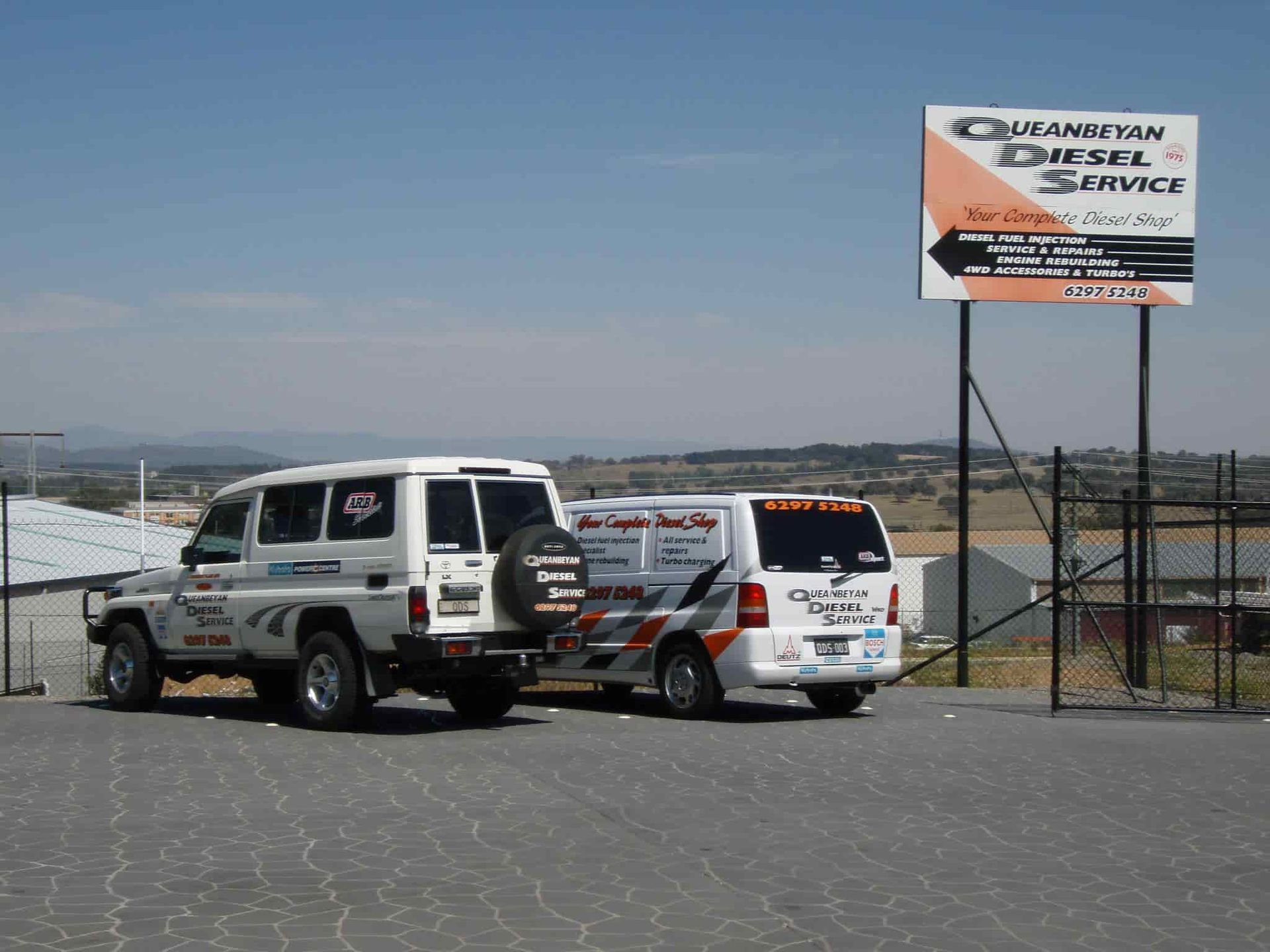 Two Vehicles Are Parked In Front Of A Sign That Says Dreamvan Diesel Service — Queanbeyan Diesel Service In Queanbeyan, East NSW
