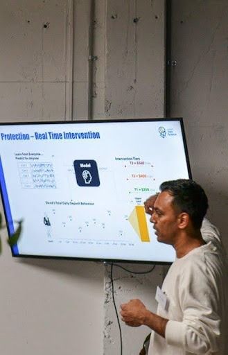 A person presents a technical slide on 