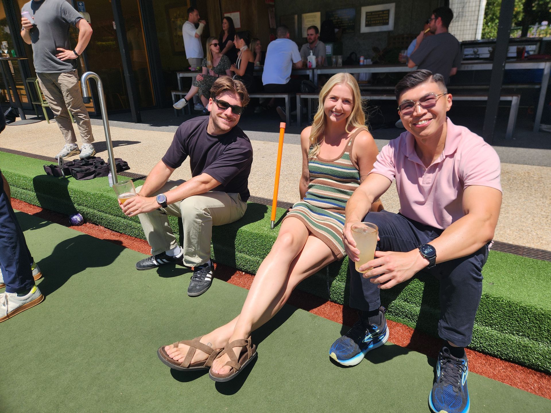 Man shaking hands with another person at a table, near a laptop and coffee cups.
