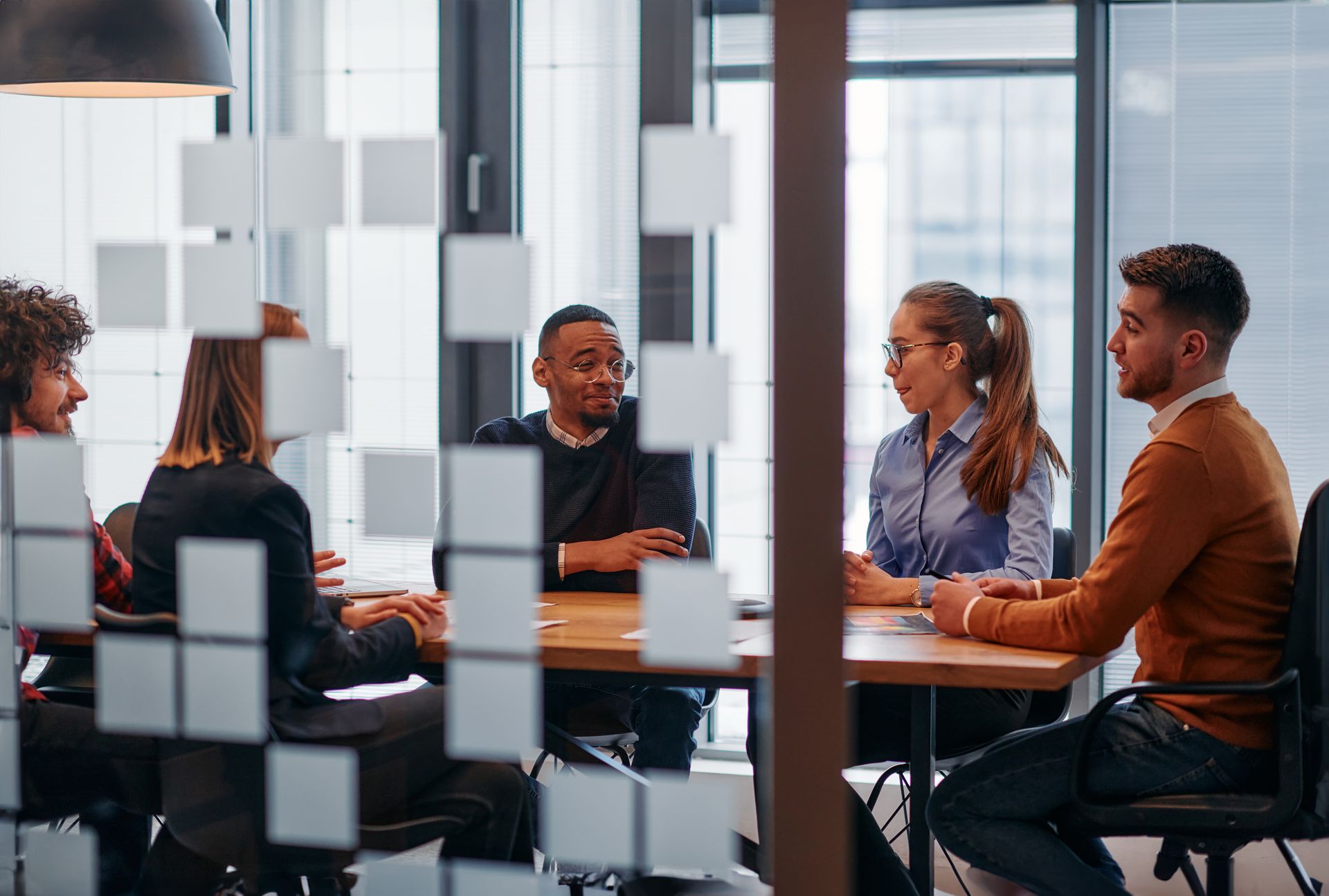 Group of people with hands together, teamwork and collaboration in an office setting.