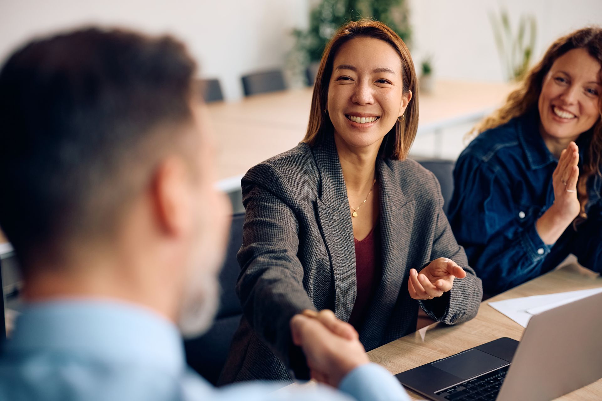 Group of people with hands together, teamwork and collaboration in an office setting.