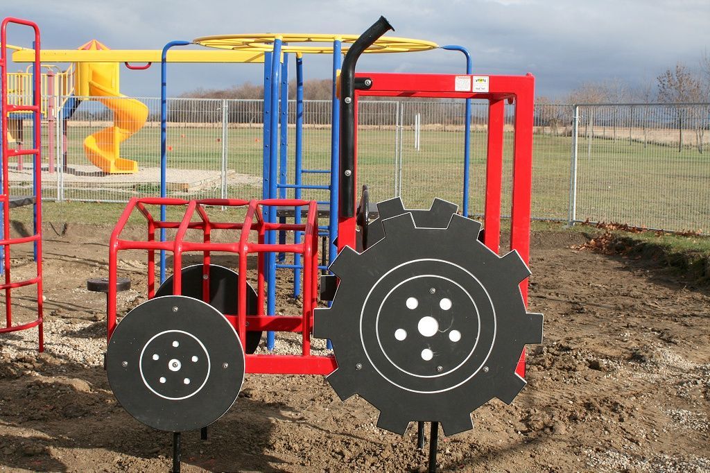 a colourful playground with a red tractor in the middle