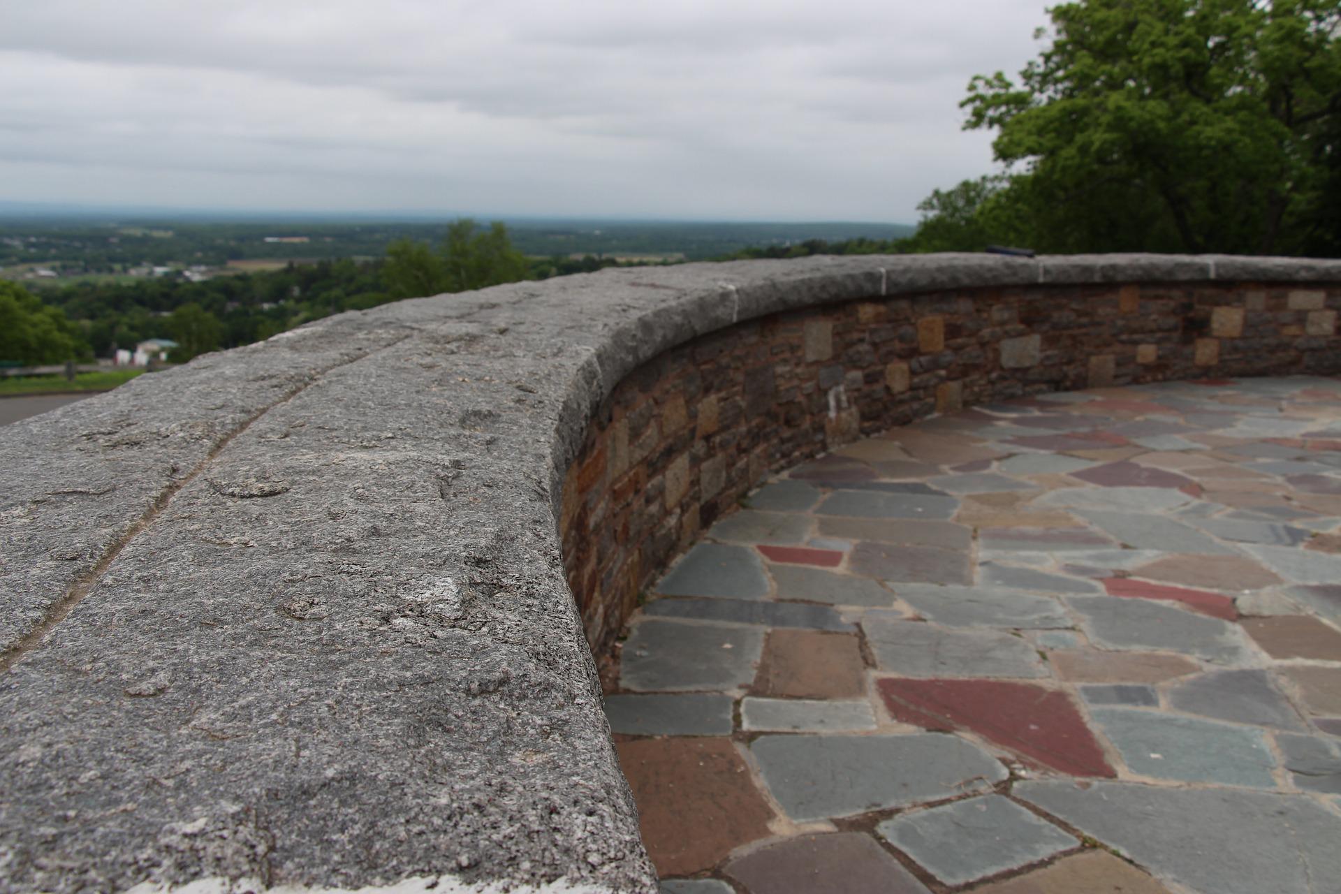 Rustic flagstone wall providing a natural and textured backdrop for the outdoor space.