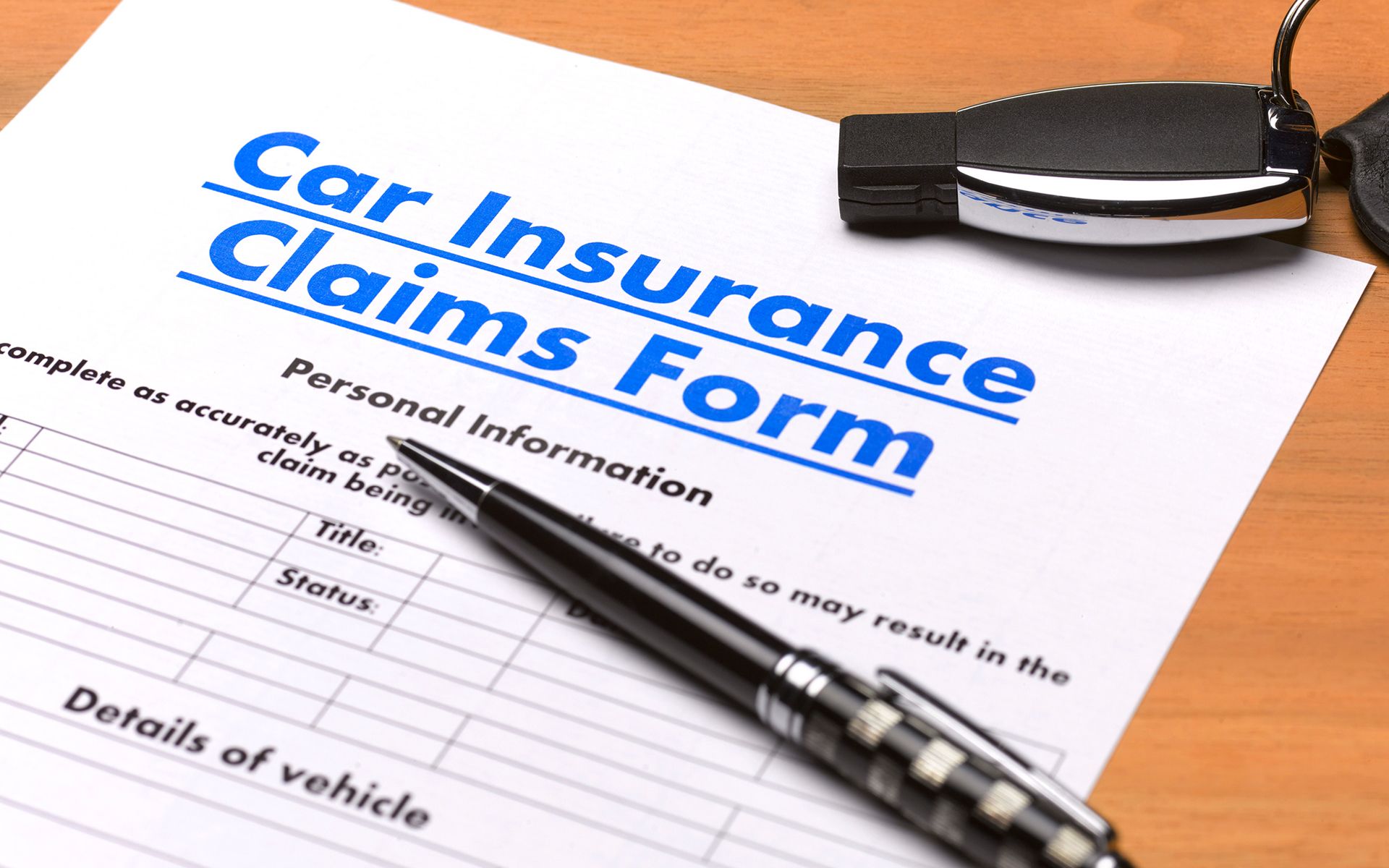 A pen is sitting on top of a car insurance claims form
