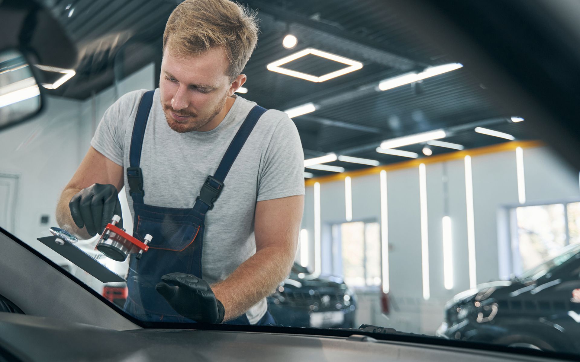 A man is installing a windshield on a car.
