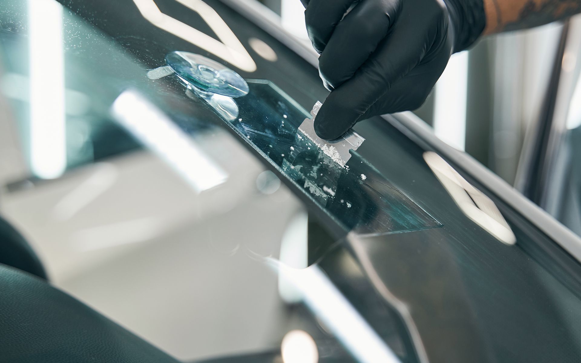 A person is repairing a windshield on a car.