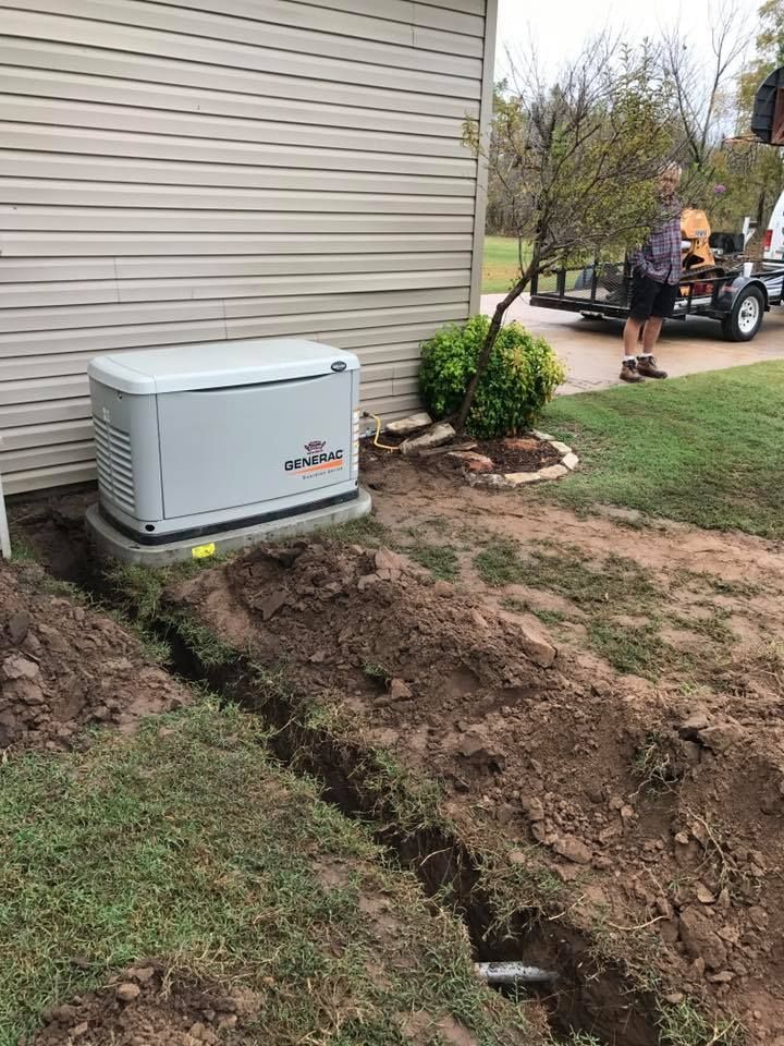 a man is standing next to a generator on the side of a house .