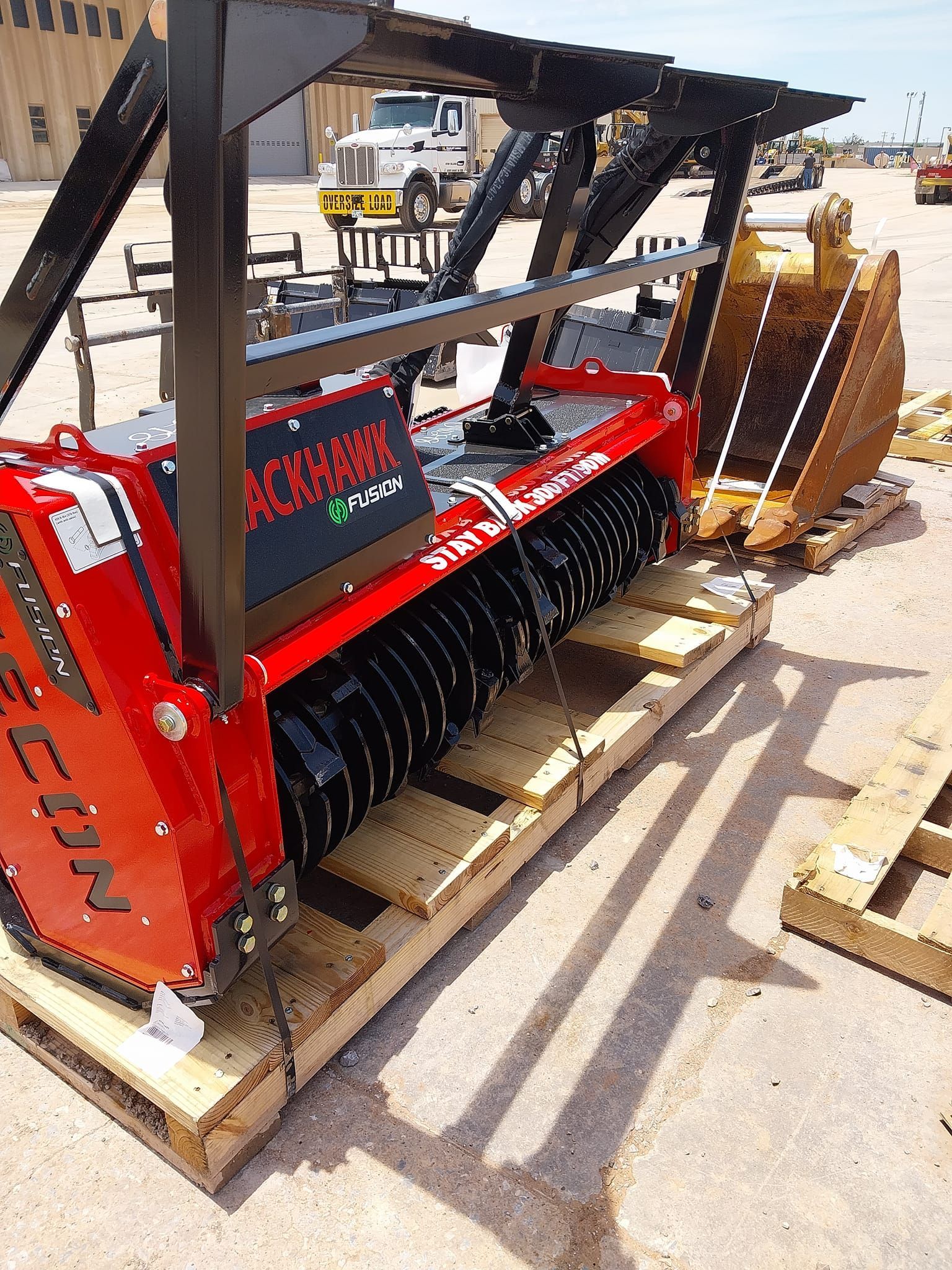 A red and black machine is sitting on a wooden pallet.