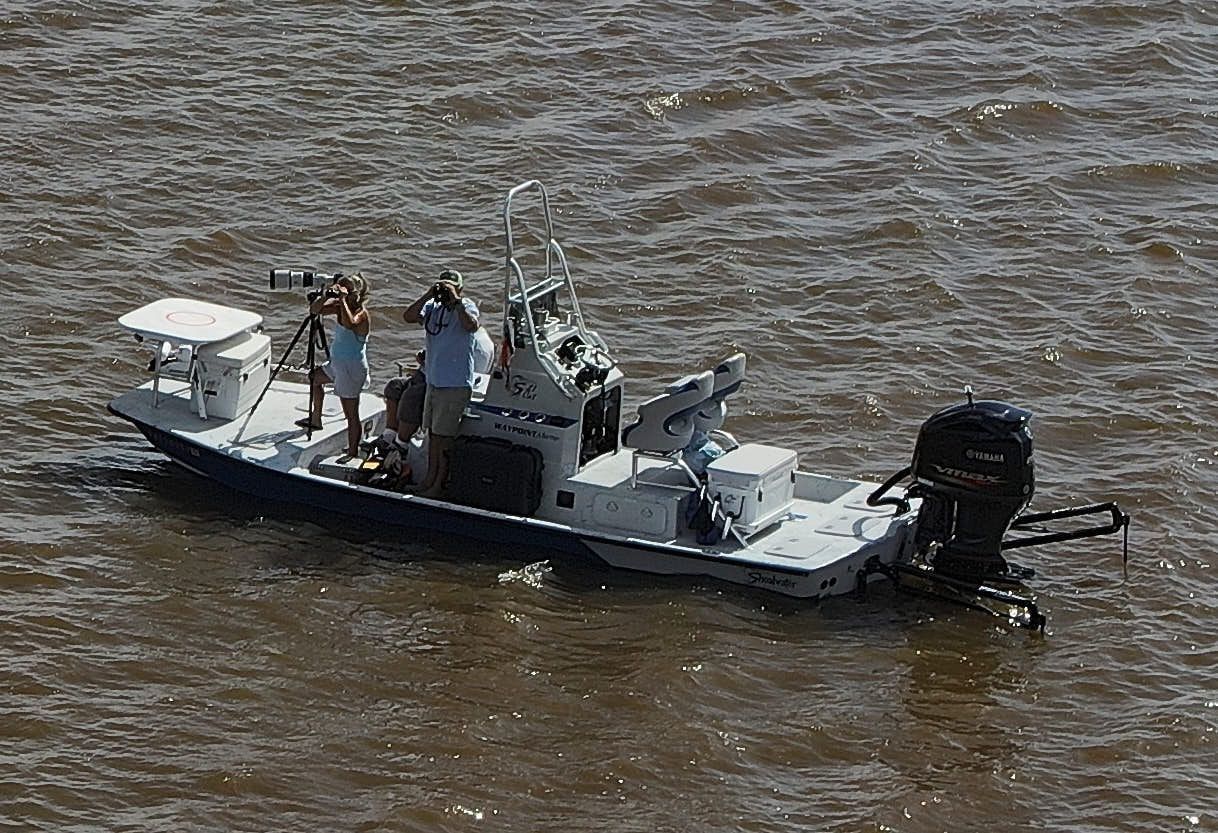 A man is sitting in a bus using a laptop computer.