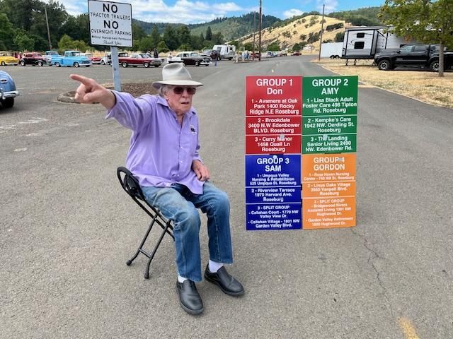 A black and white photo of three old cars parked in a parking lot.