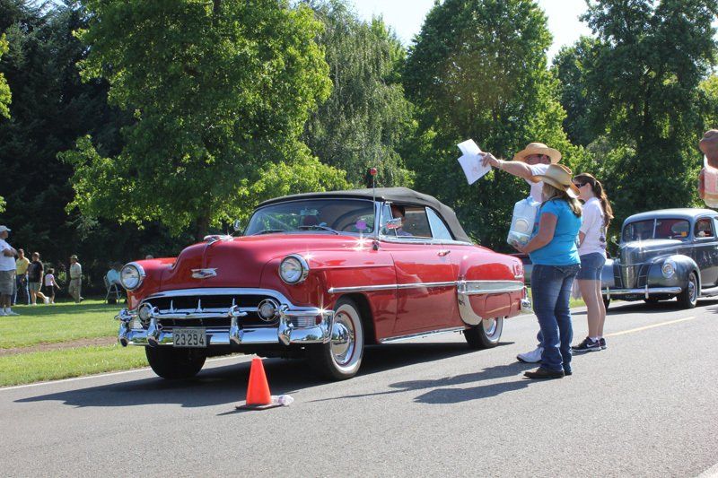 A red car is parked on the side of the road