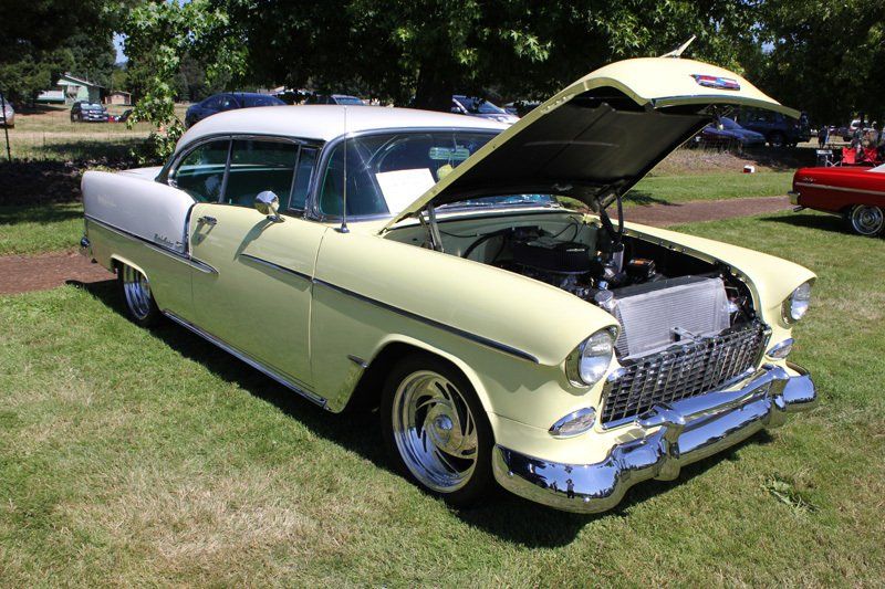 A yellow and white car with the hood open