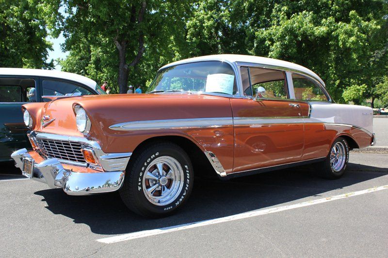 A brown and white car is parked in a parking lot