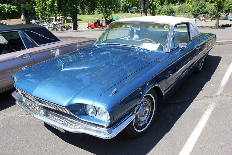 A blue car with a white top is parked in a parking lot