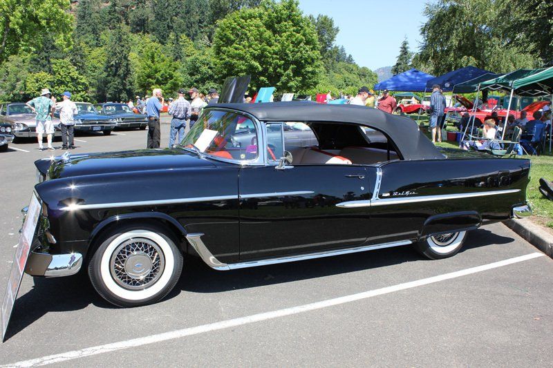 A black convertible car is parked in a parking lot