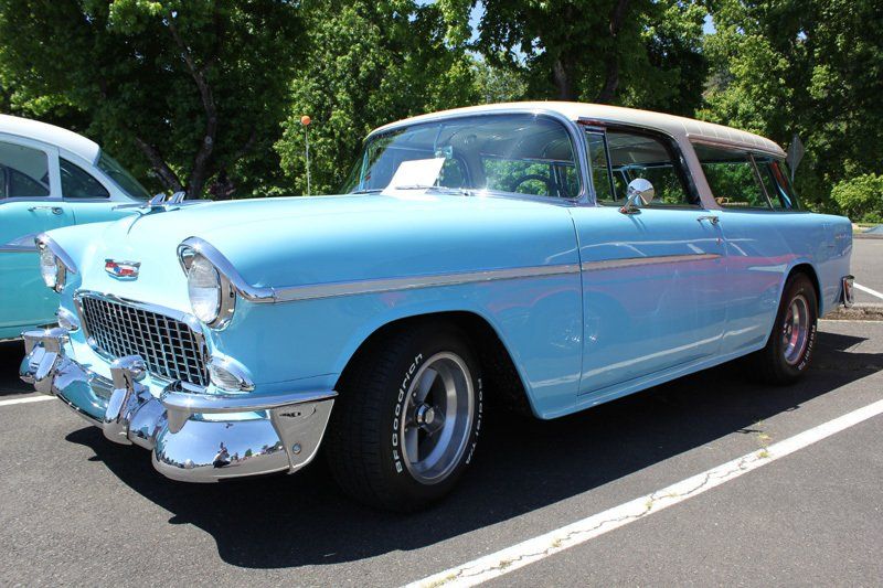 A blue and white car is parked in a parking lot